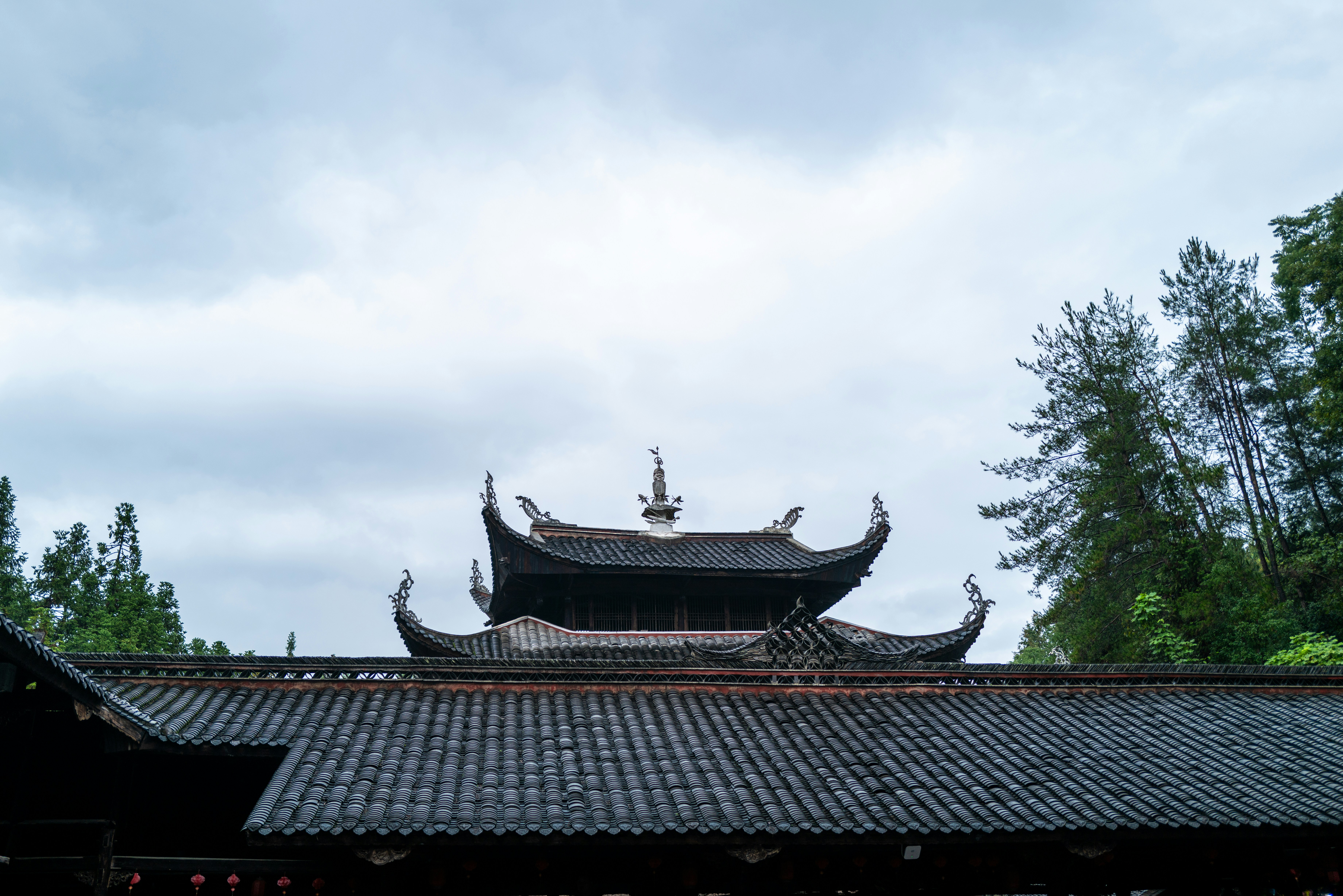 Traditional chinese temple roofs against a cloudy sky