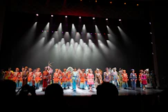 Performers in colorful costumes on a stage.