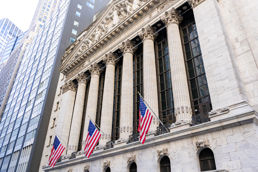 The New York Stock Exchange building on Wall Street, its columned facade hung with American flags