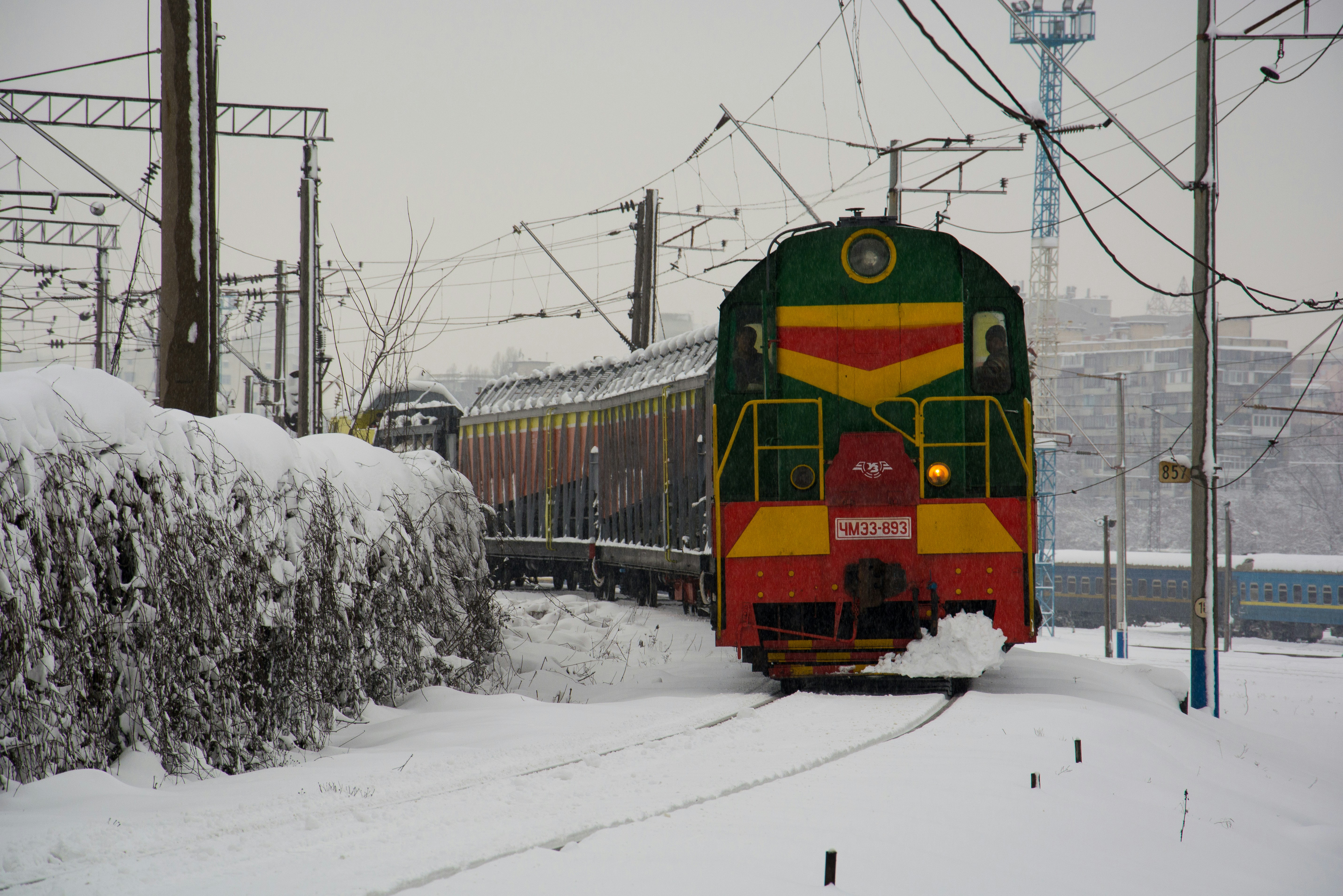 A colorful train travels through a snowy landscape.