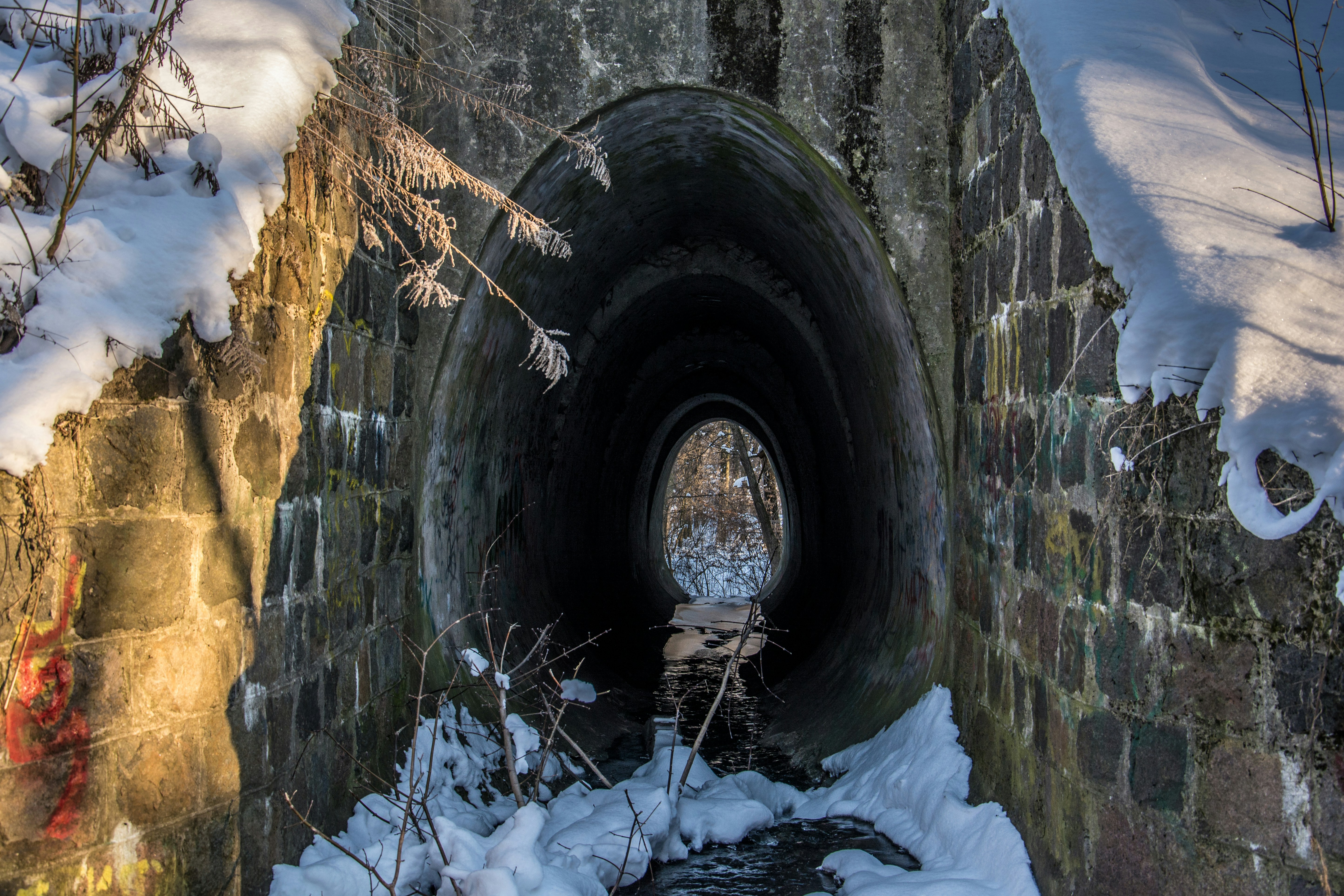 Snowy tunnel entrance with stone arches and brick walls