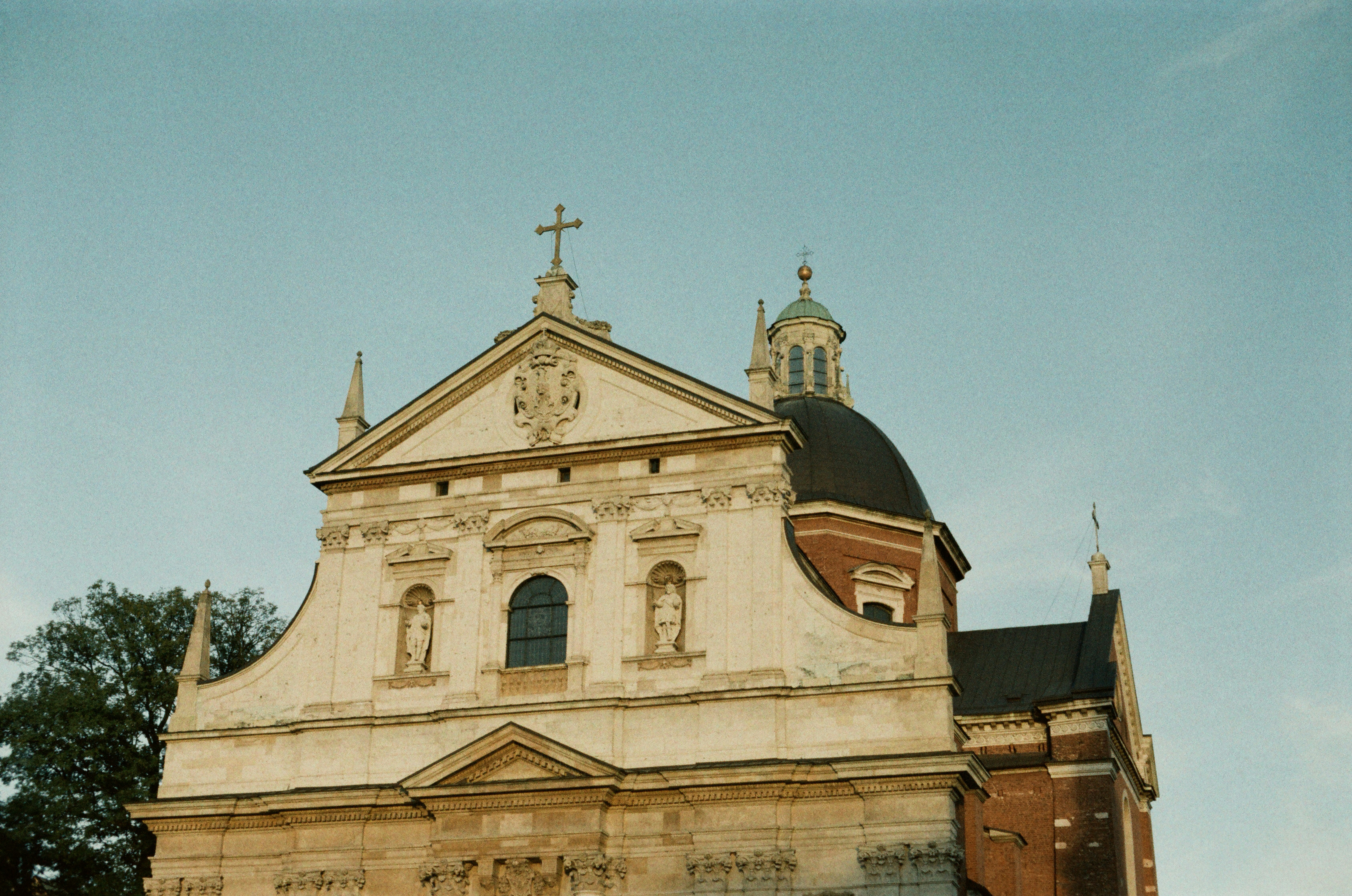Baroque church facade with a dome against blue sky