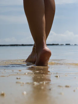 Bare feet walking on a wet sandy beach