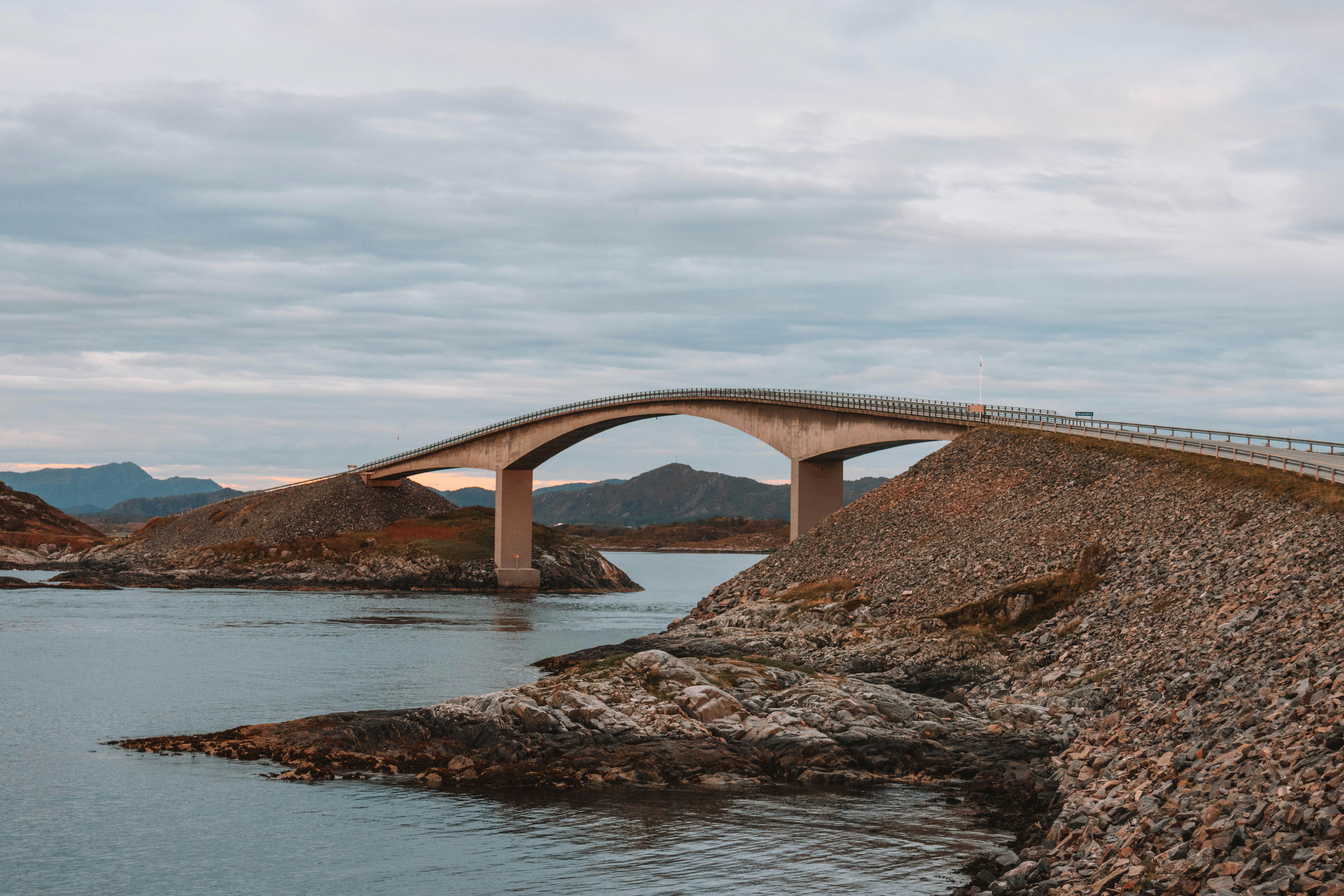Curving bridge over the sea with rocky shores
