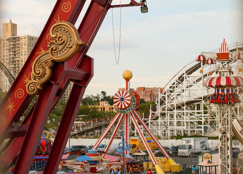 Amusement park rides with roller coaster in background
