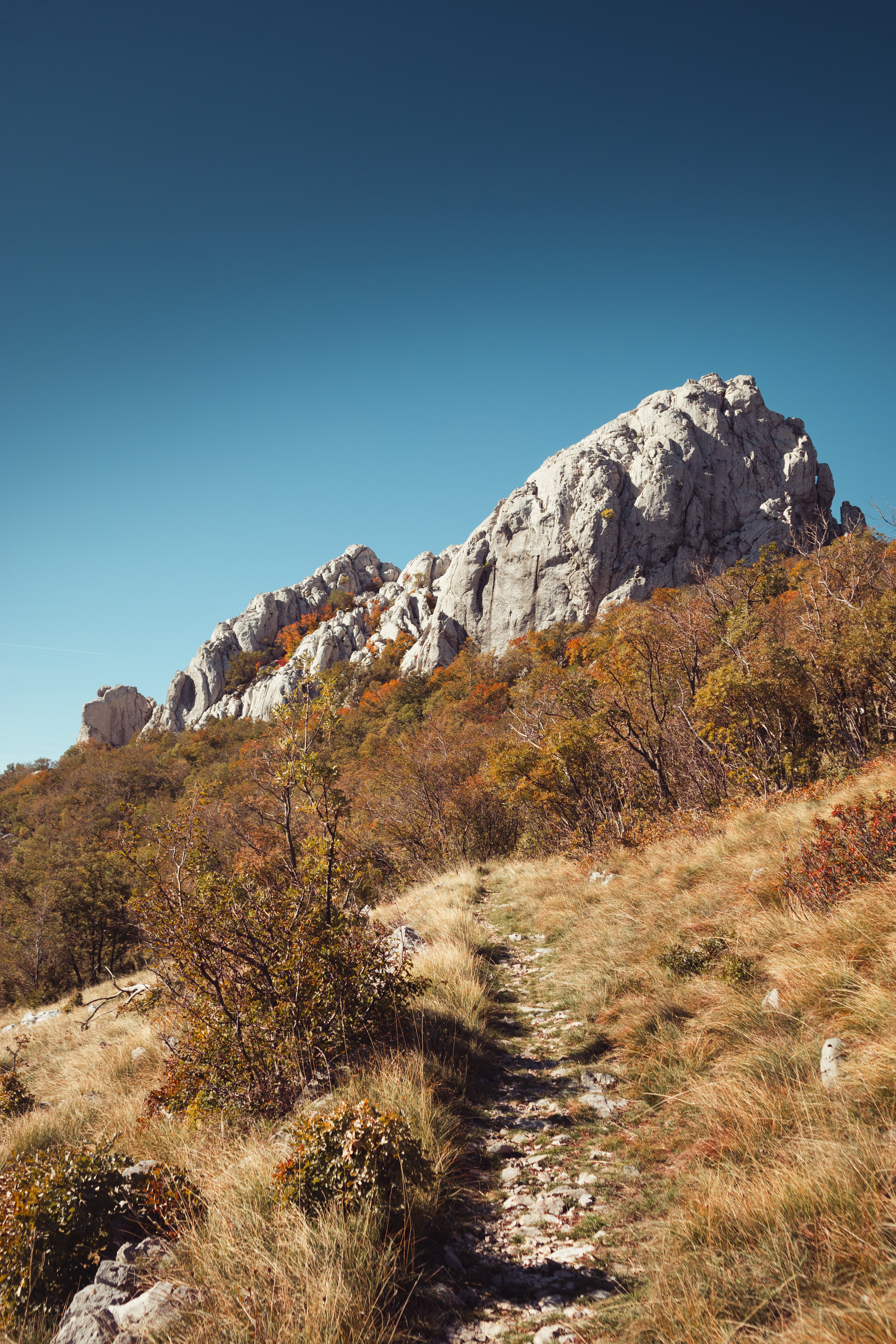Rocky mountain path under a clear blue sky