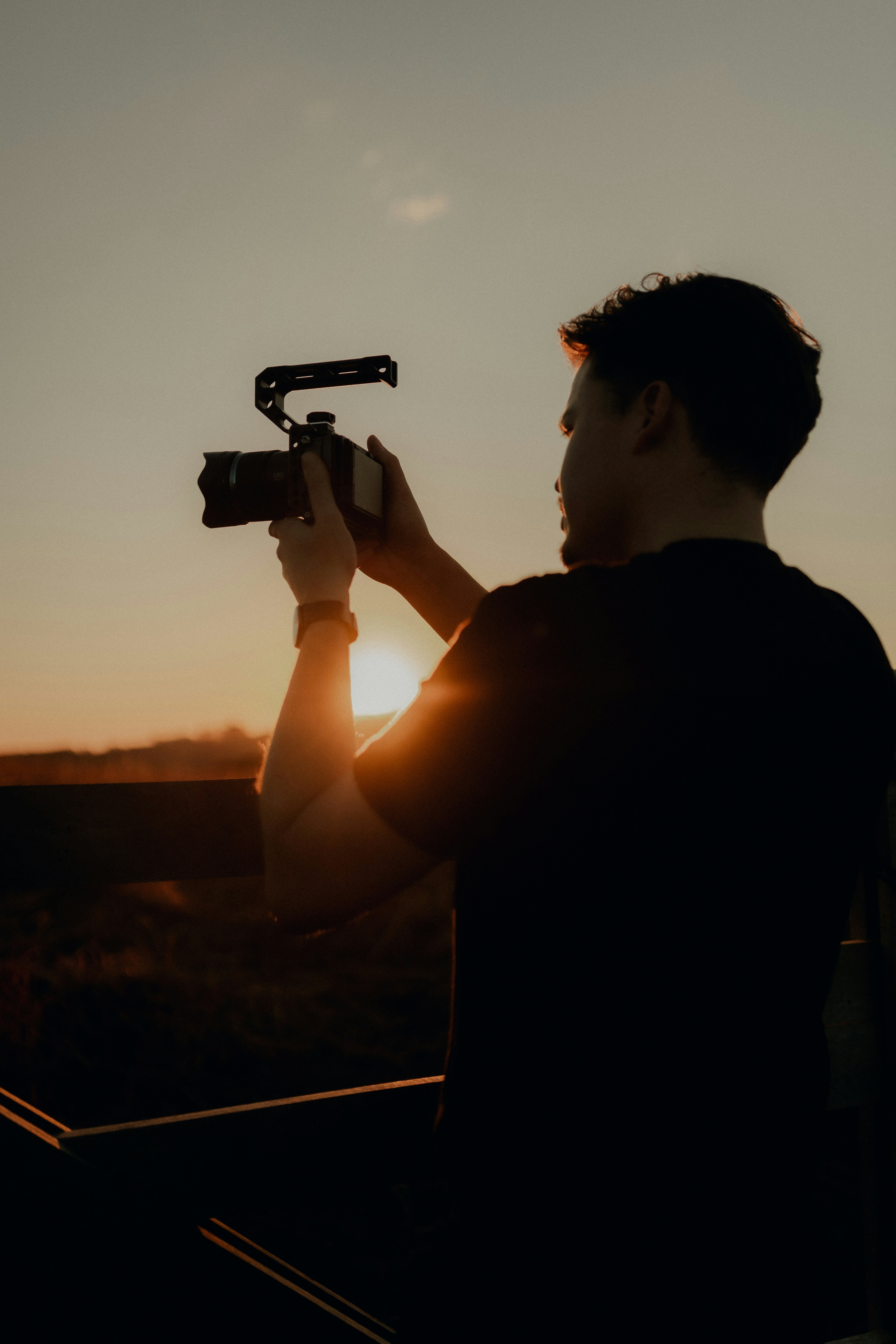 Man filming sunset with a professional camera