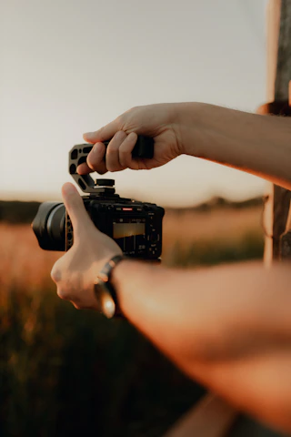 Hands holding a camera with a handle