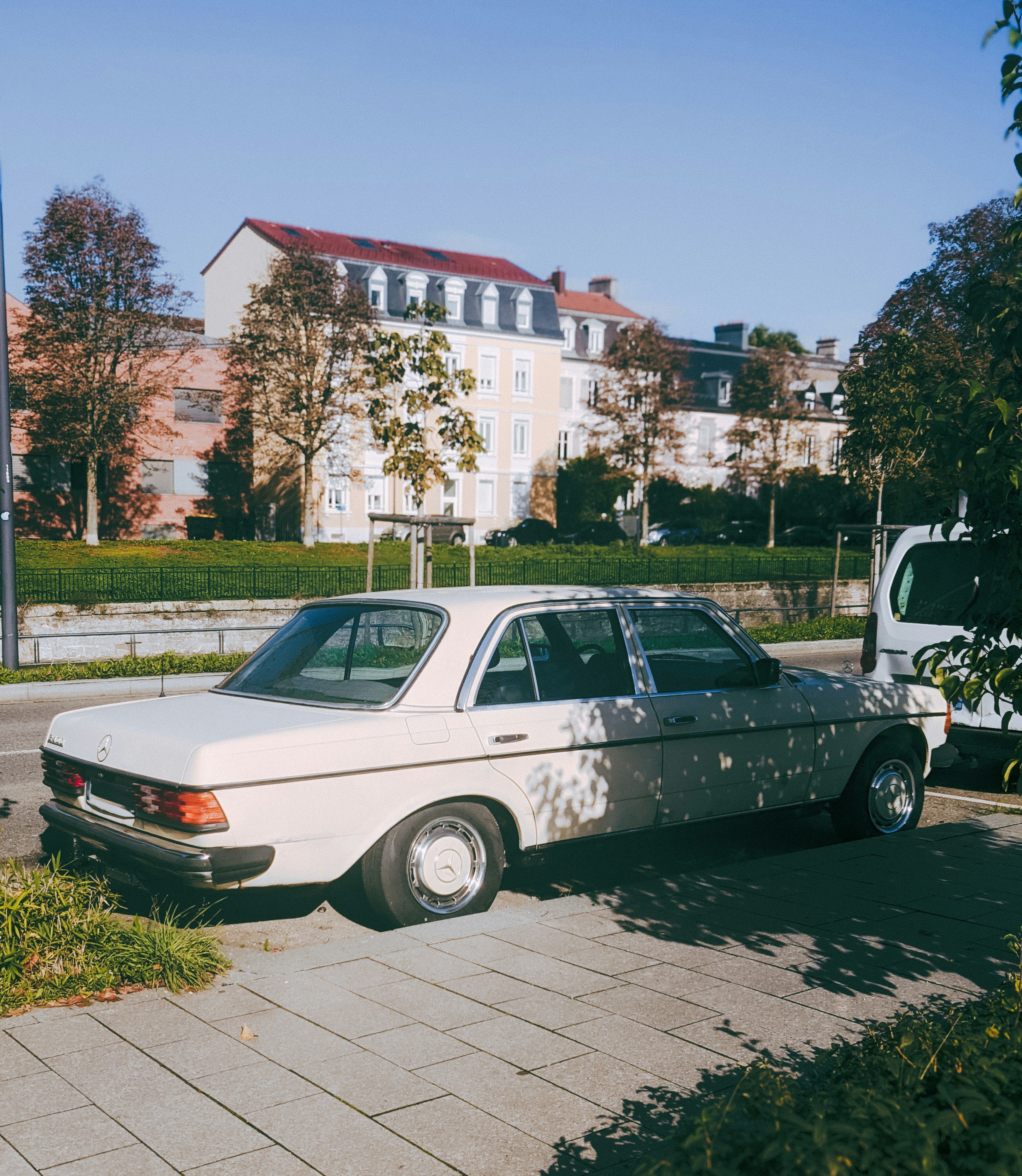 White vintage car parked on a city street.