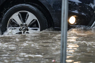Car driving through floodwater splashes