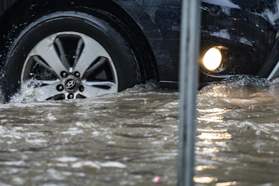 Car driving through floodwater splashes
