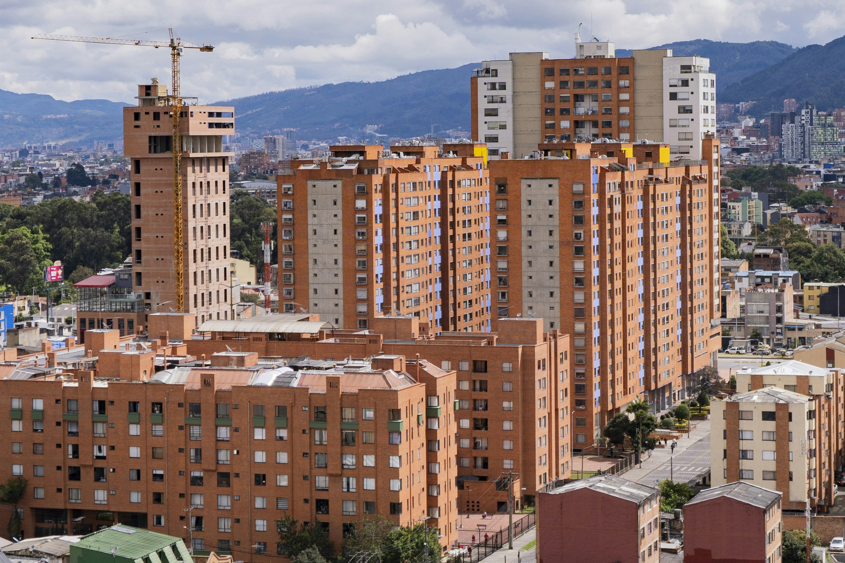 Tall brick apartment buildings under a cloudy sky.