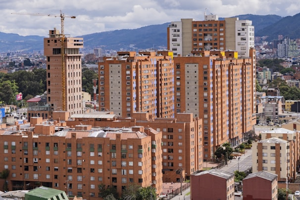 Tall brick apartment buildings under a cloudy sky.