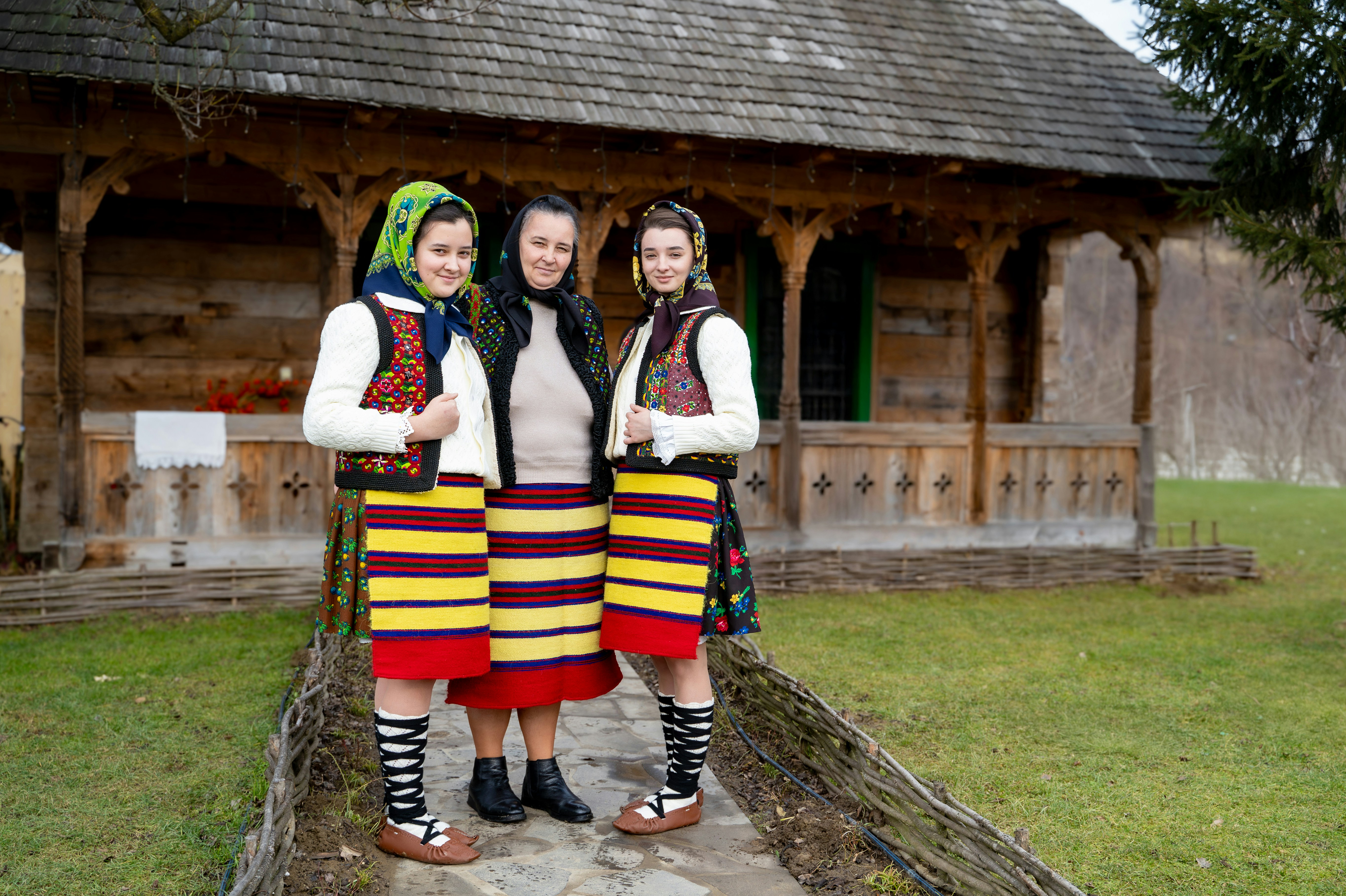 Three women in traditional romanian folk costumes.