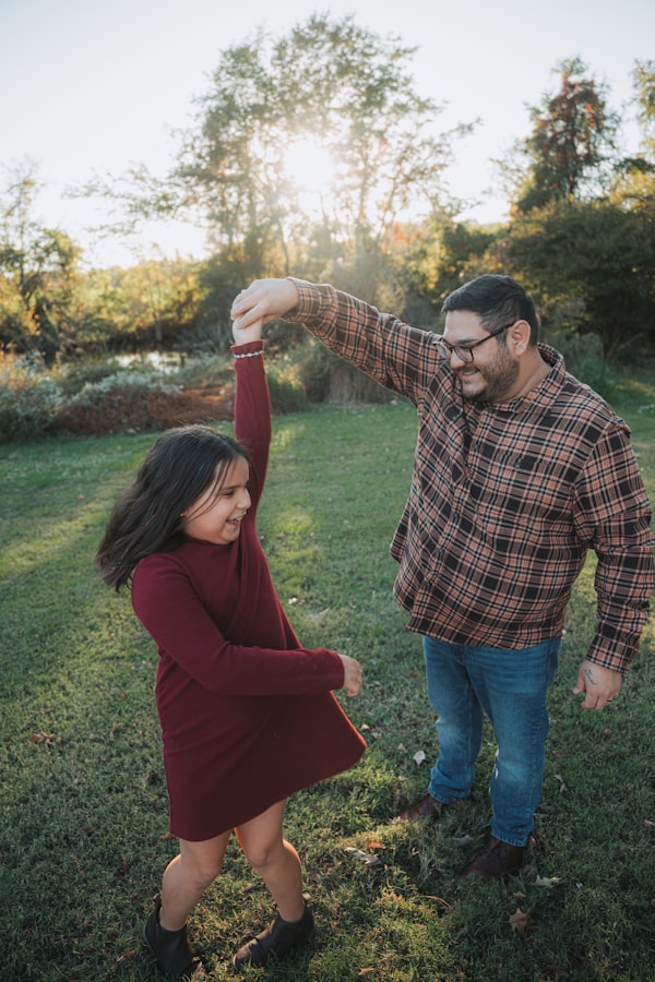 Father and daughter dancing in a park