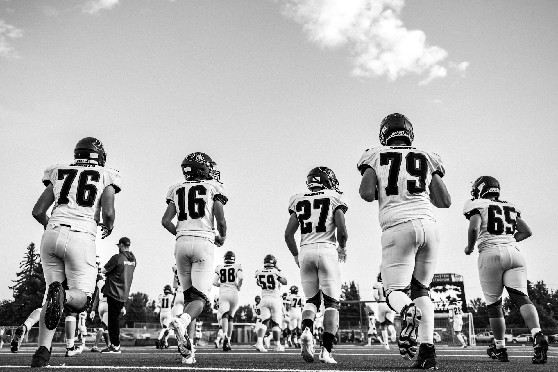 Football players running onto the field during a game.