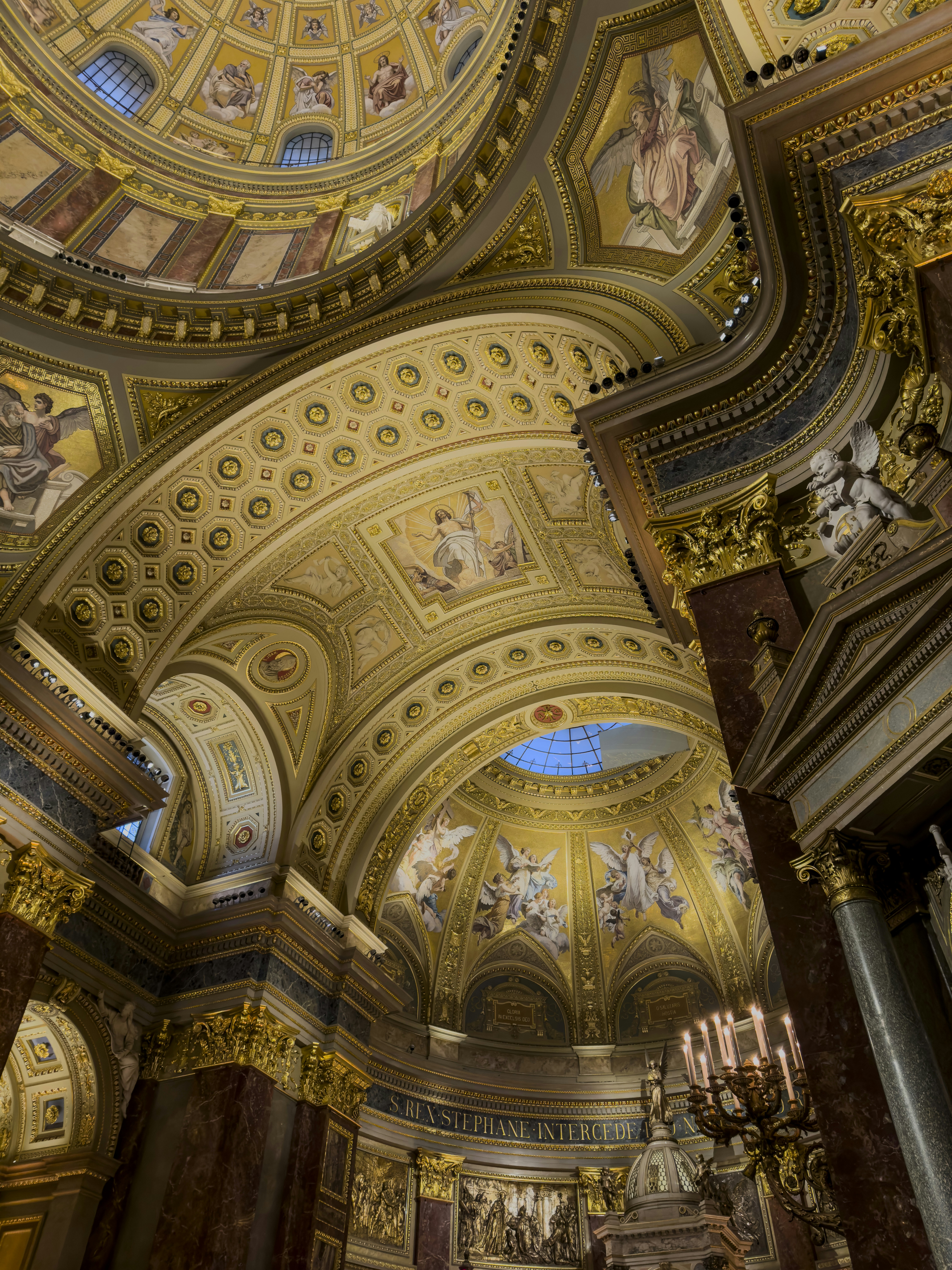 Ornate golden dome interior with religious paintings and architectural details.