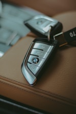 Two BMW car keys resting on leather seats.