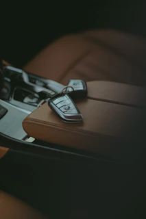 Car keys resting on a leather car seat.