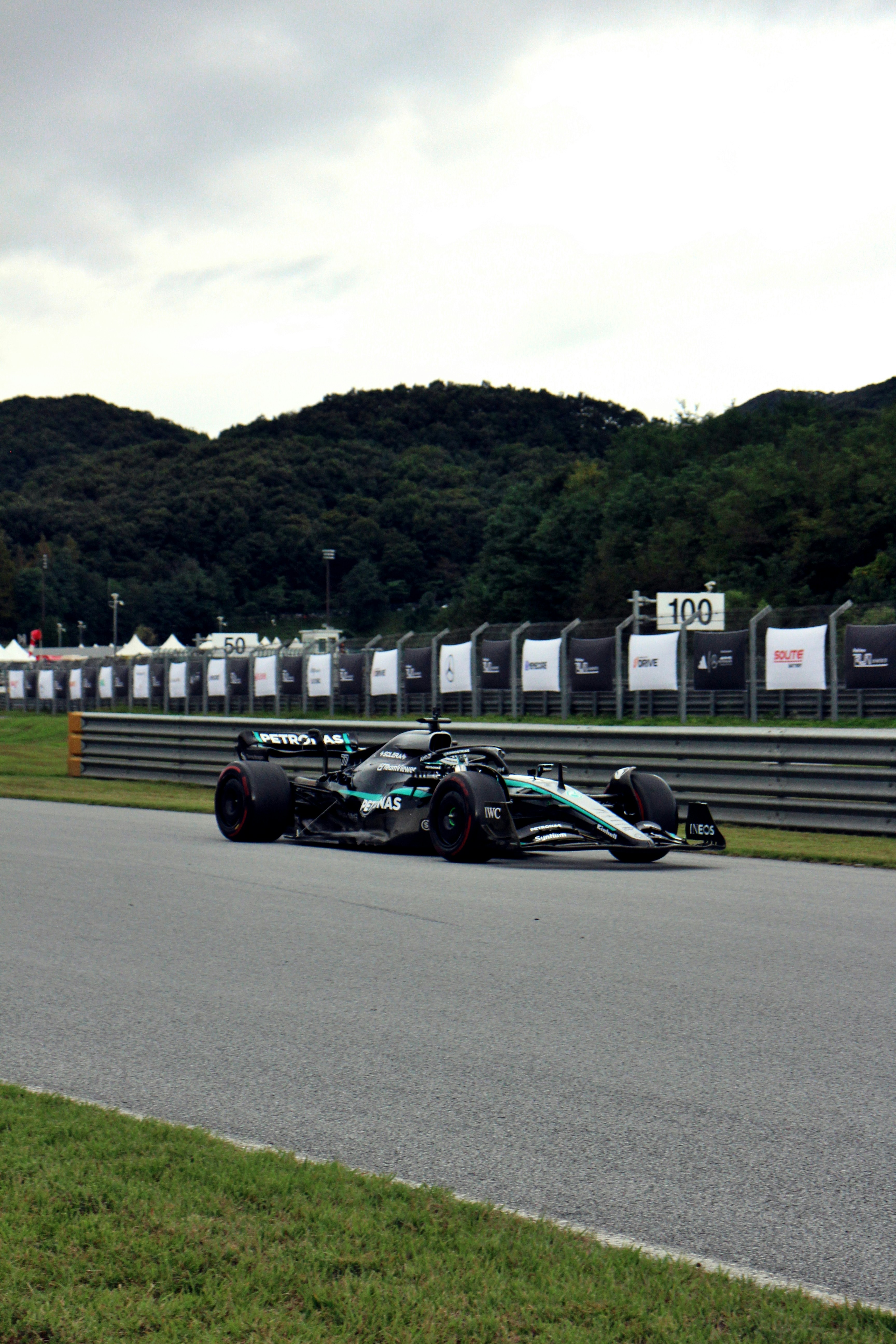 Auto da corsa di Formula 1 in pista con sfondo di alberi