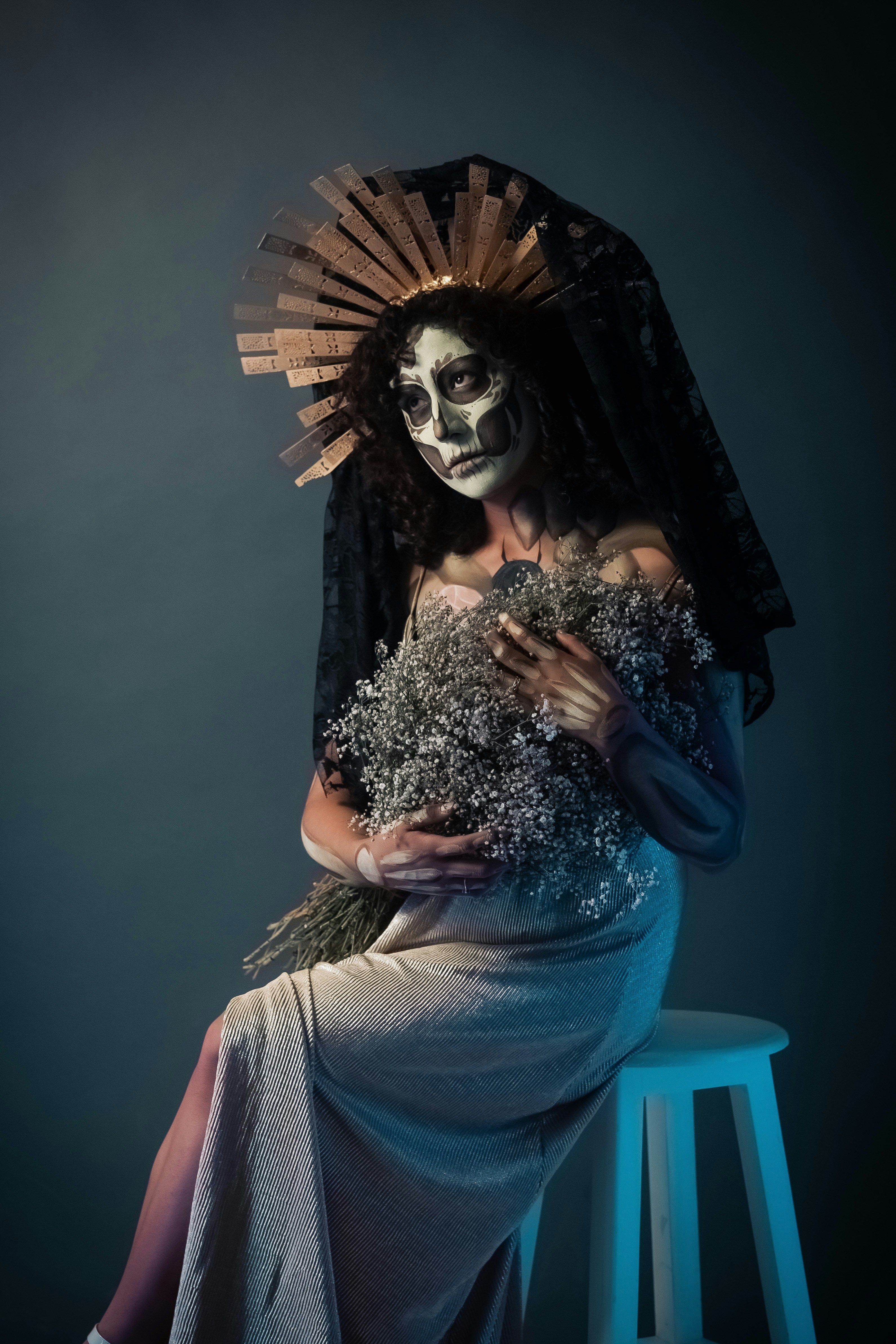 Mulher com pintura facial de caveira segura buquê de flores