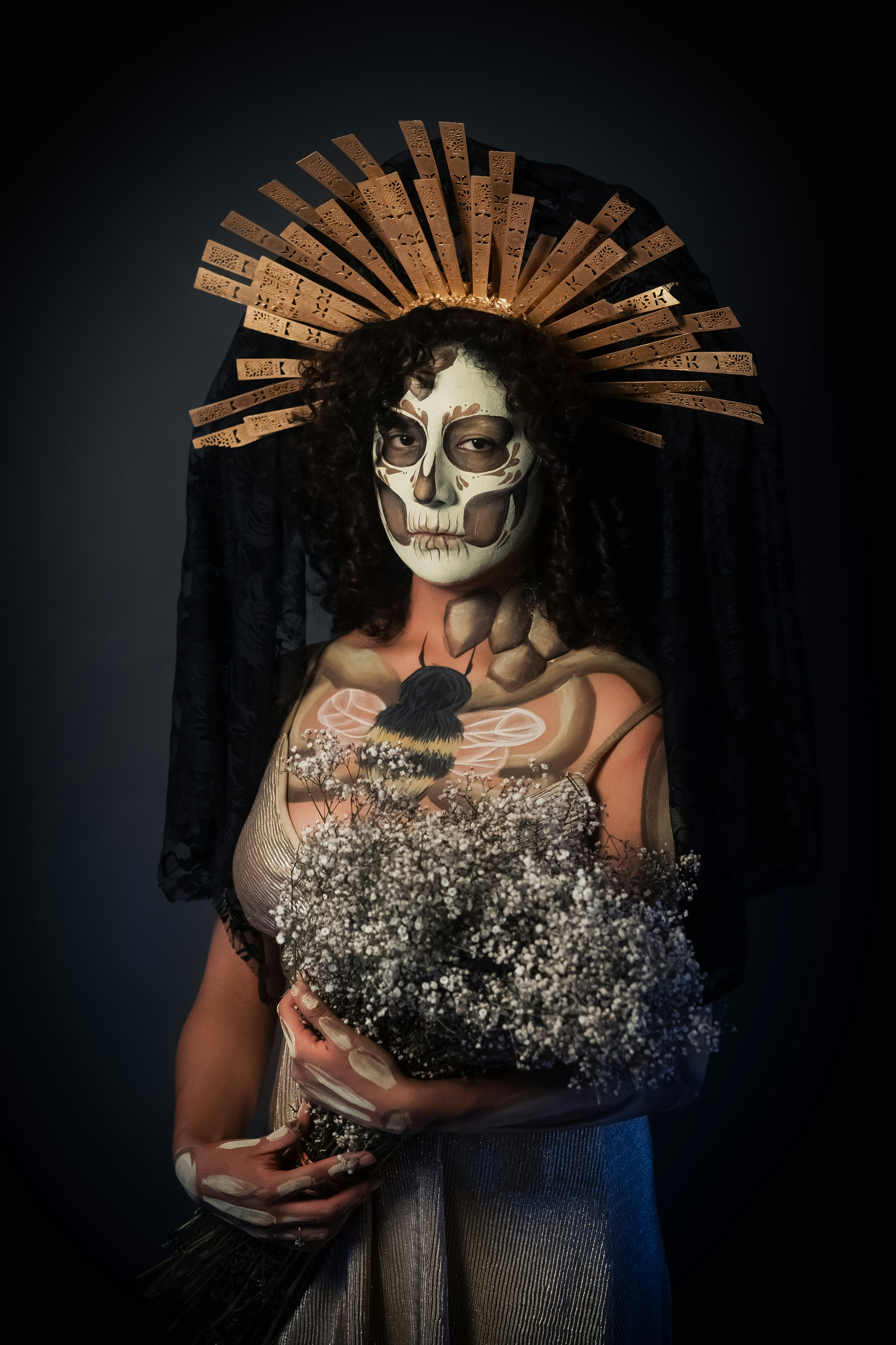 Mulher com pintura facial de caveira segurando flores brancas