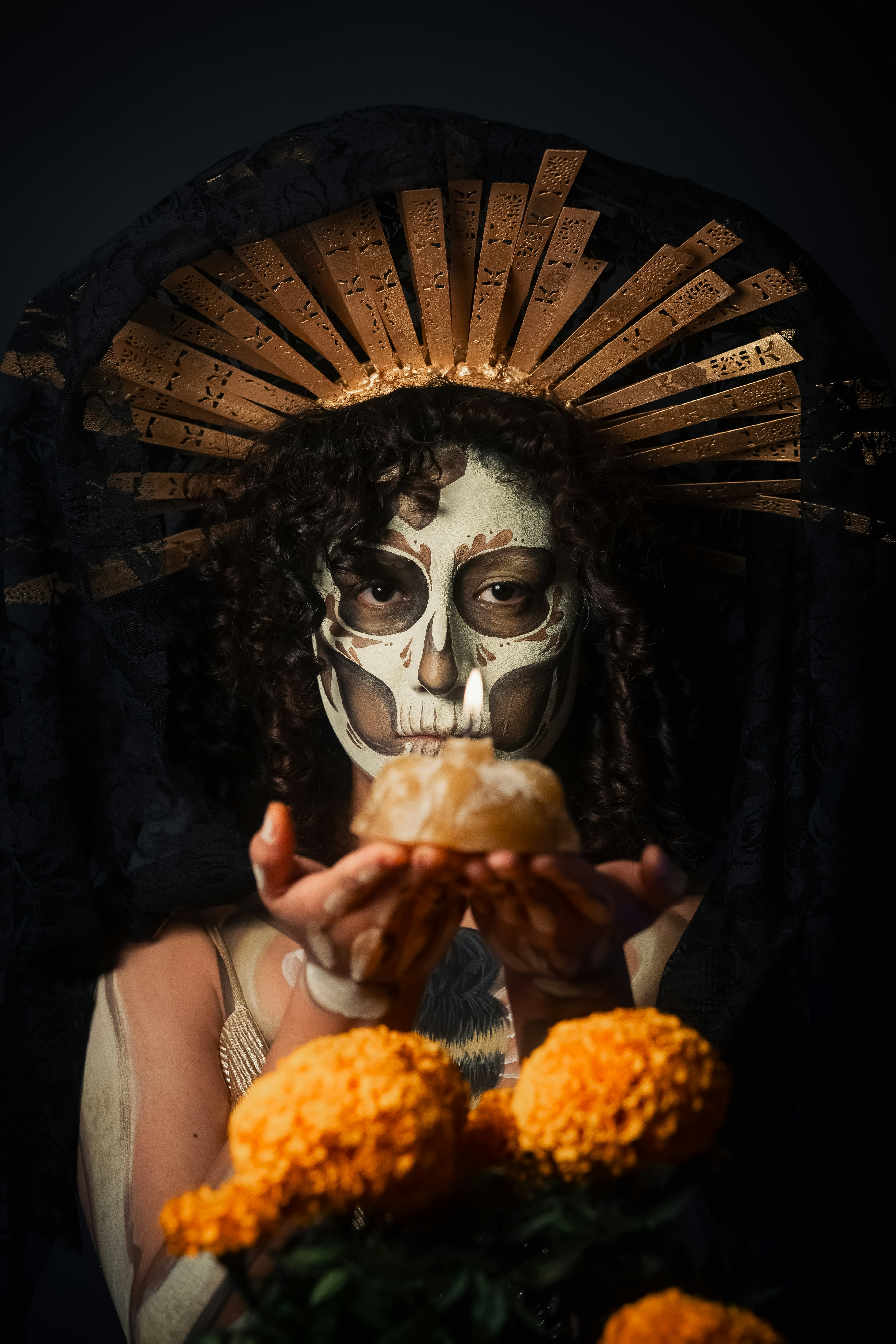 Mulher com pintura facial de caveira segura oferenda com malmequeres