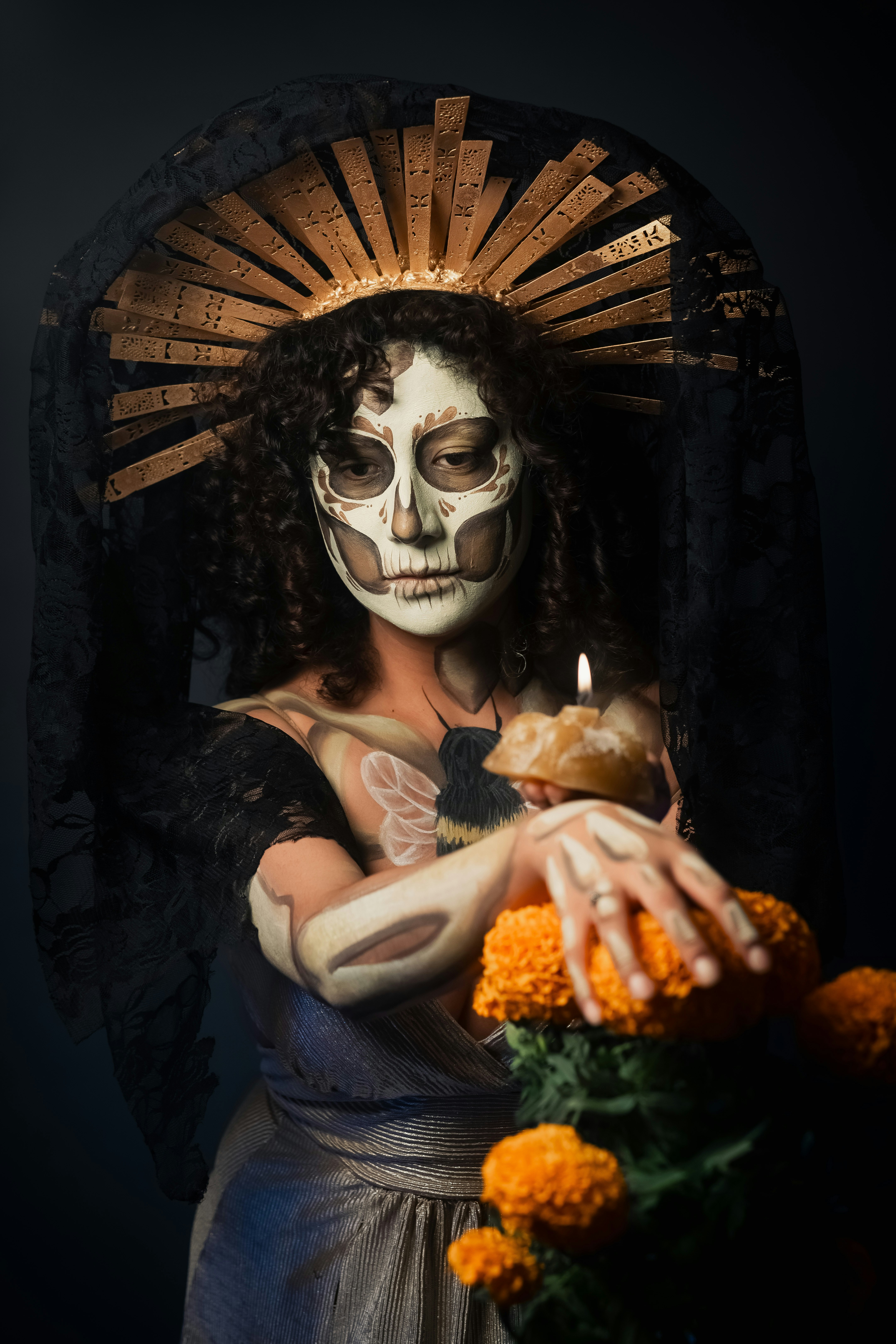 Mulher com maquiagem dia de los muertos segurando malmequeres