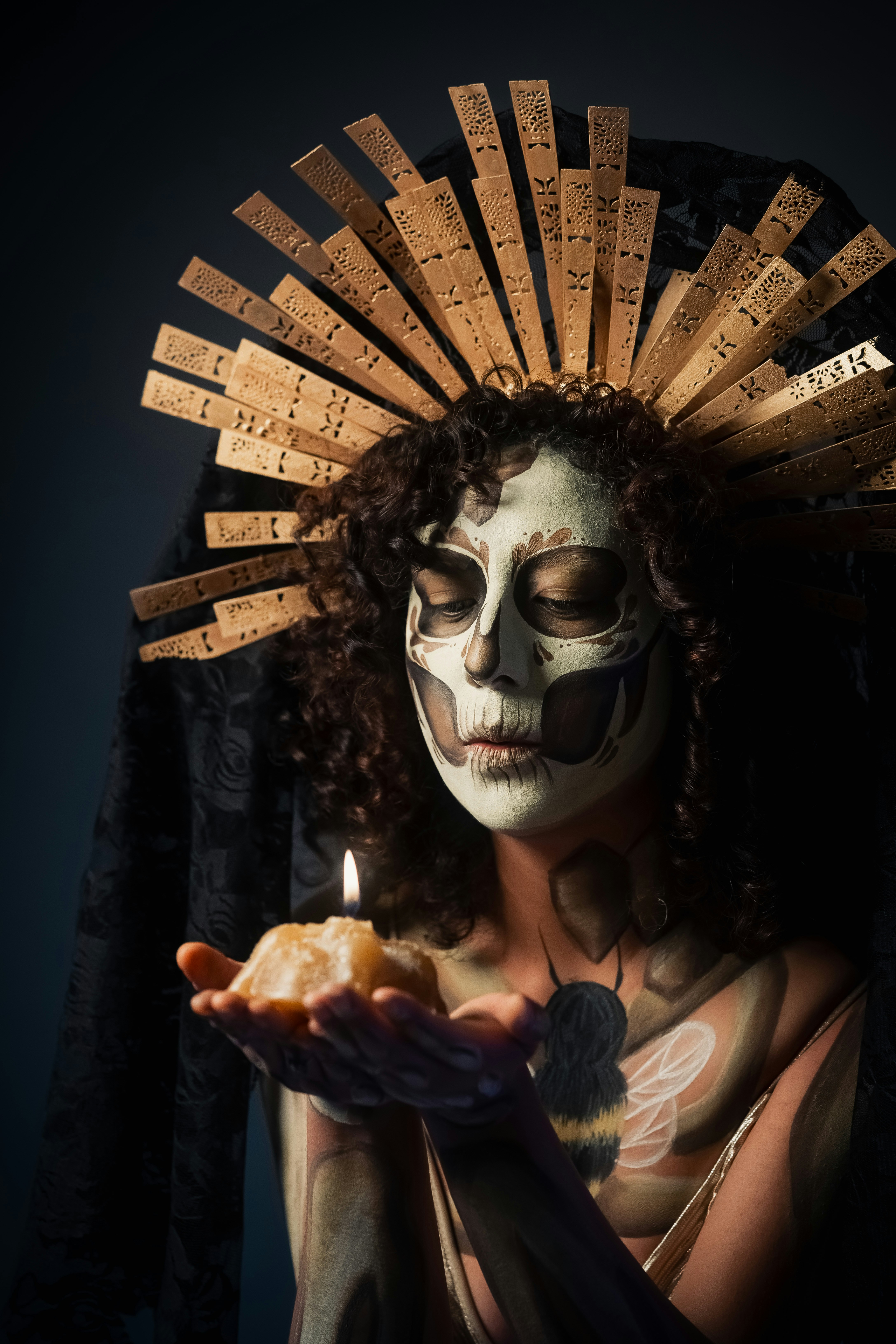 Mulher com pintura facial de caveira segurando uma vela acesa