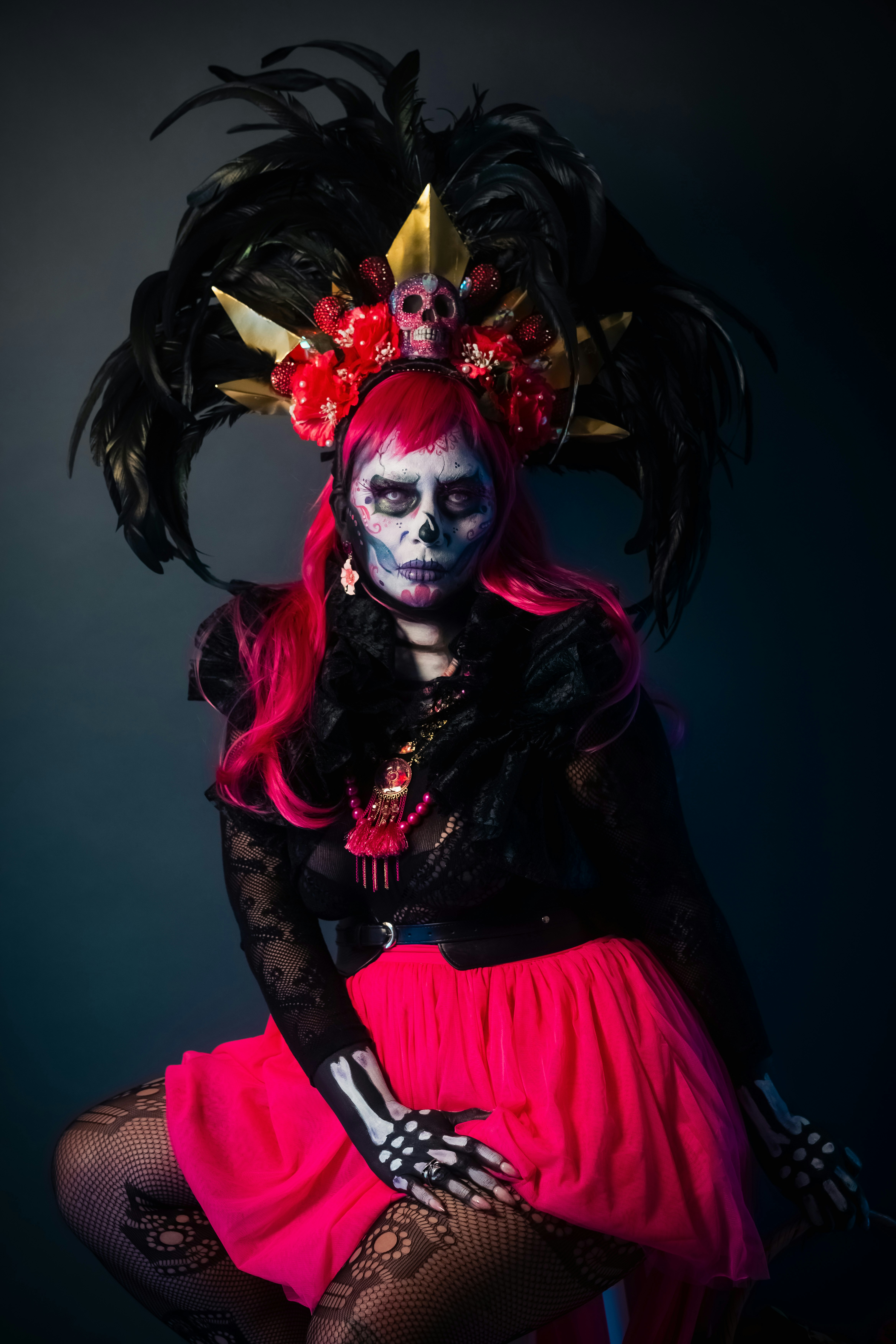 Mulher com pintura facial de caveira e cabelo rosa