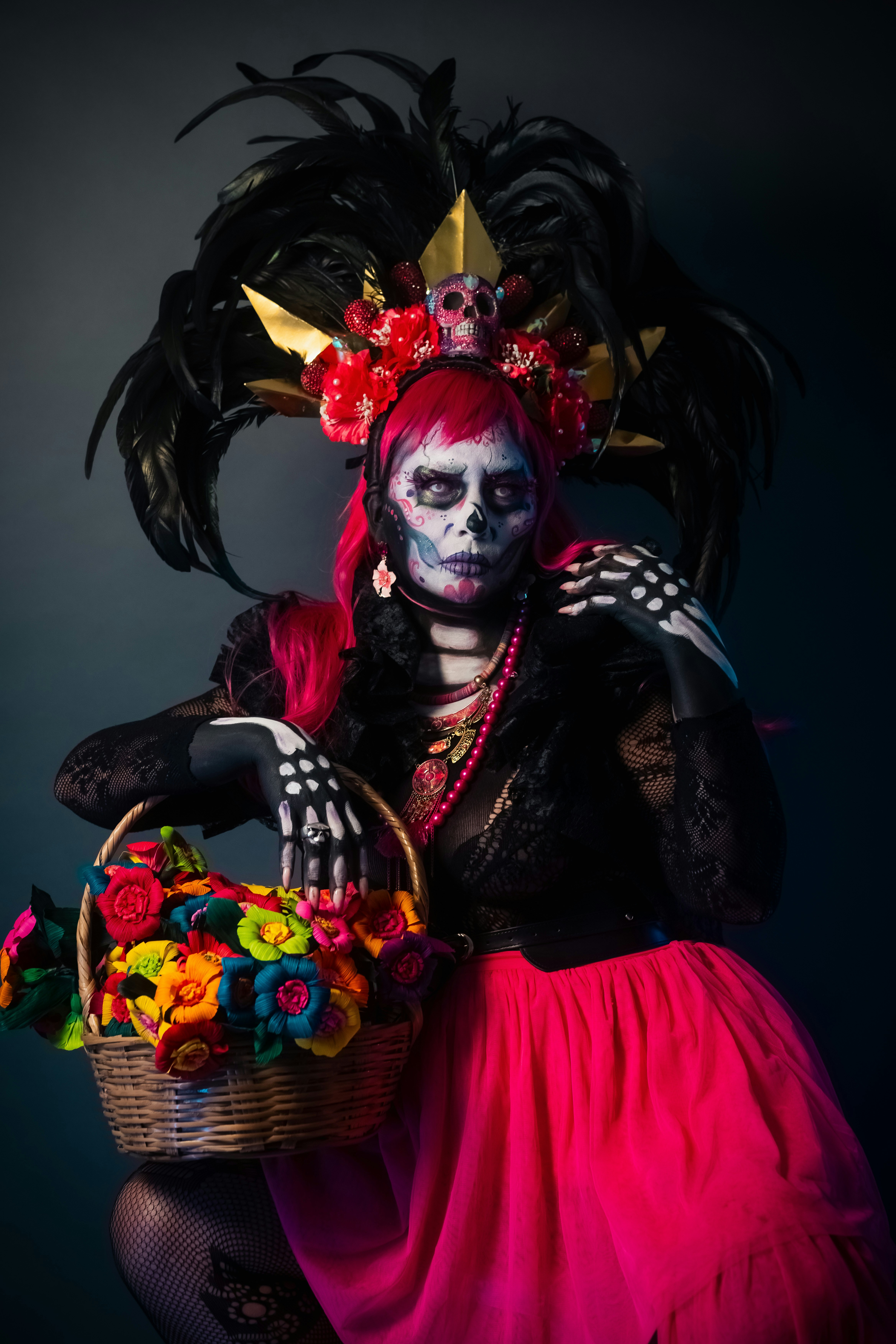 Mulher no traje do dia de los muertos que guarda a cesta da flor