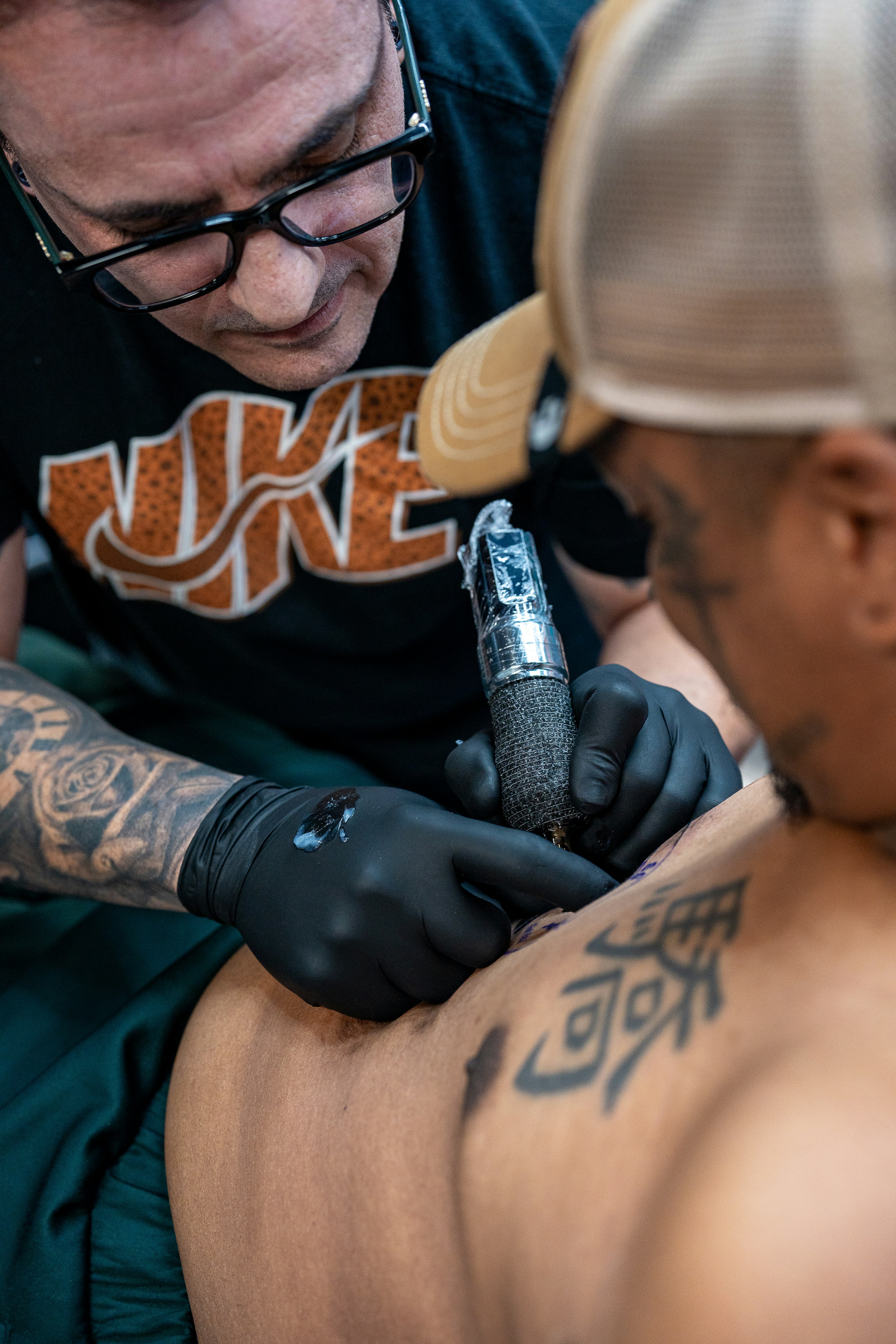 Tätowierer, der am Arm des Kunden arbeitet