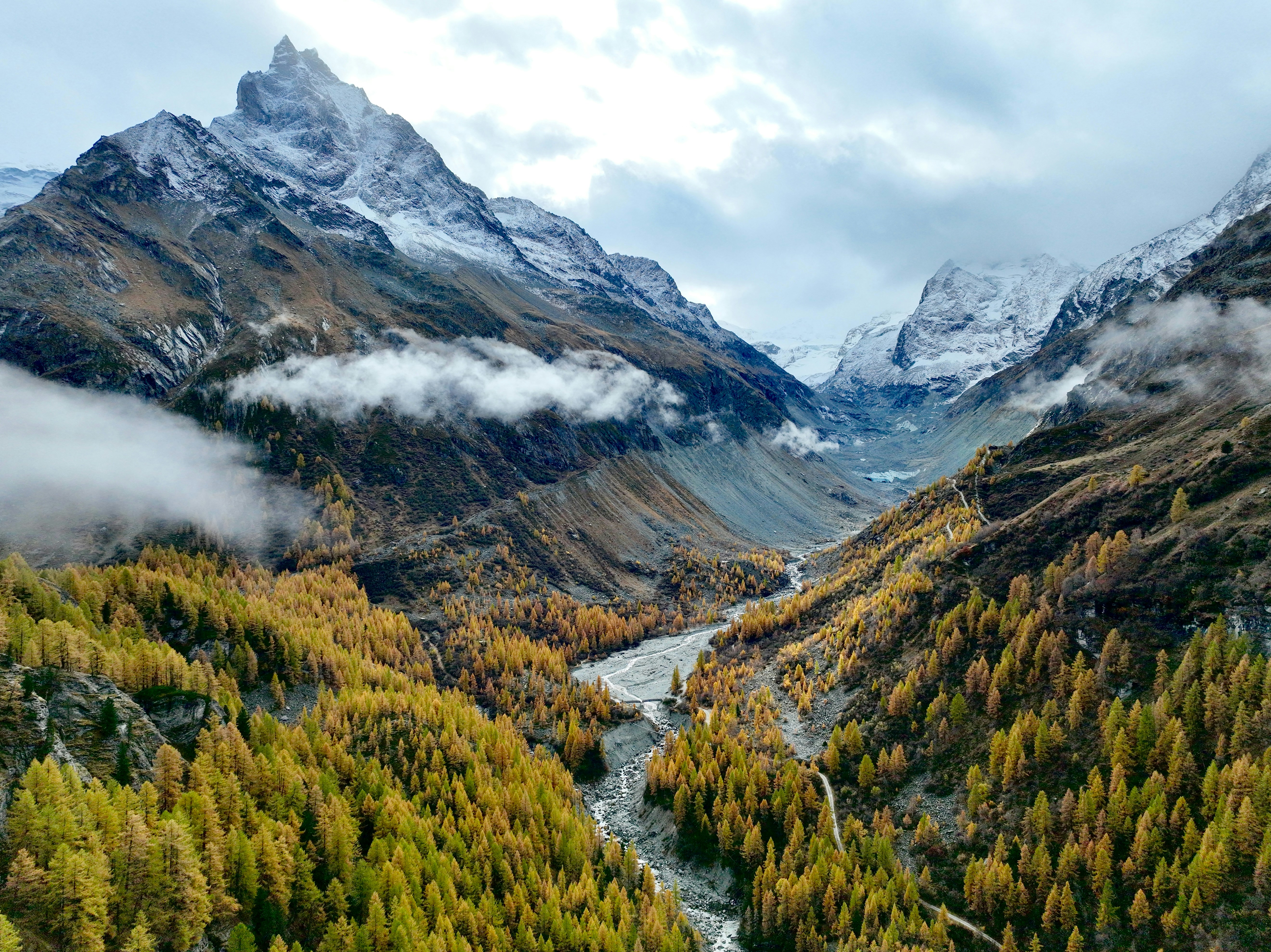 Autumn valley with river and snow-capped mountains
