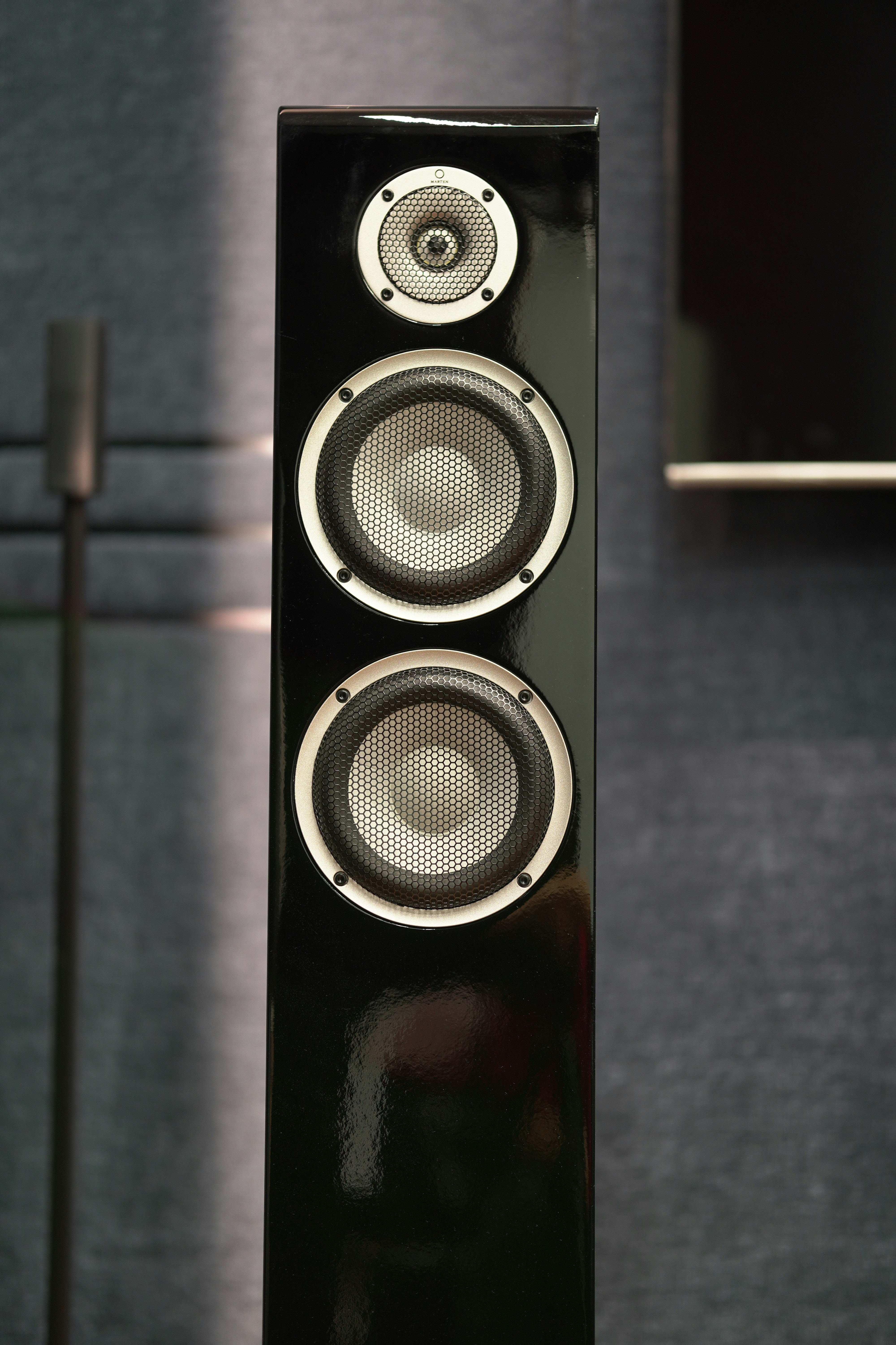 Un altavoz negro alto con tres controladores.