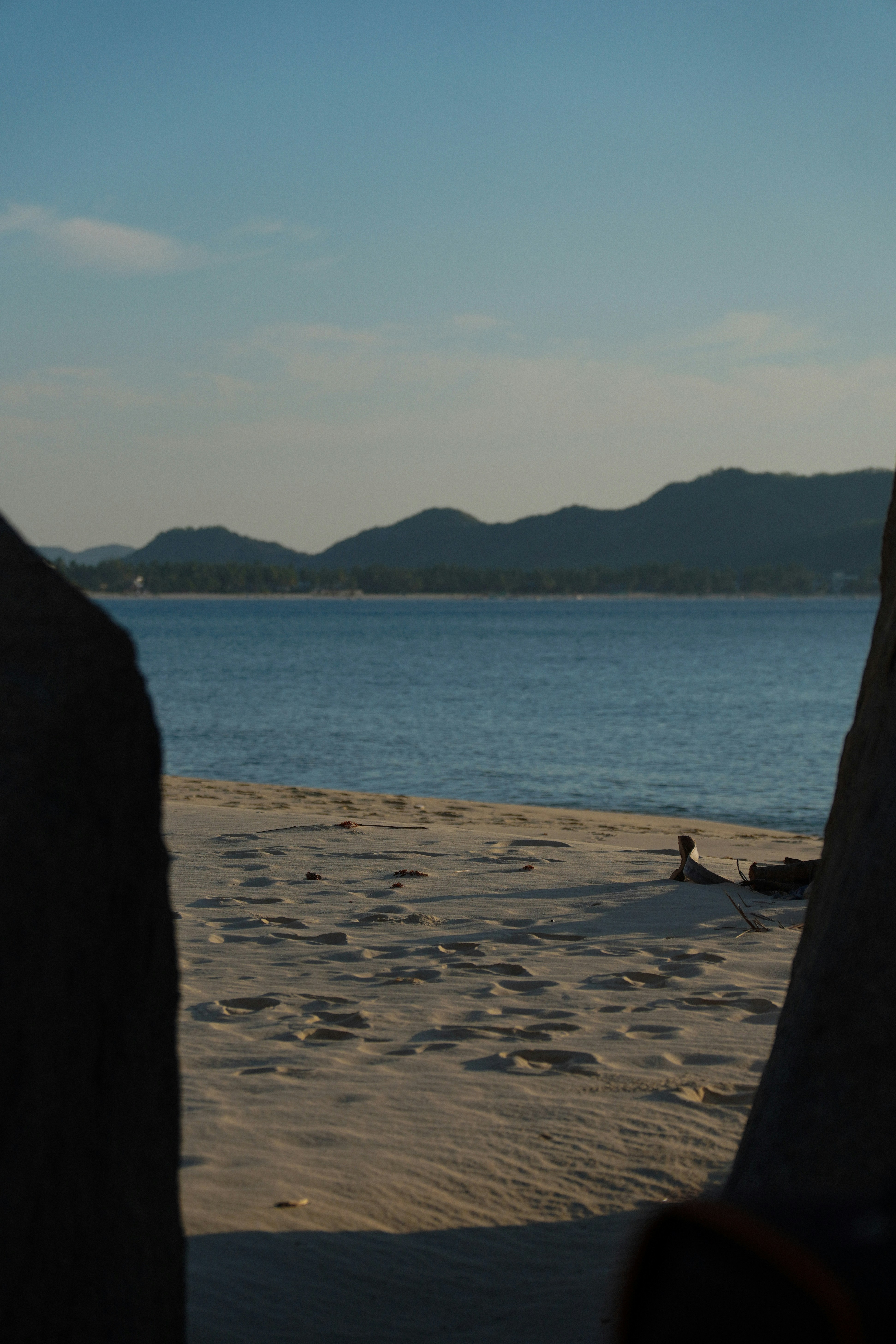 Calm ocean view with sandy beach and distant hills
