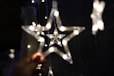 Hand holding a string of star-shaped lights