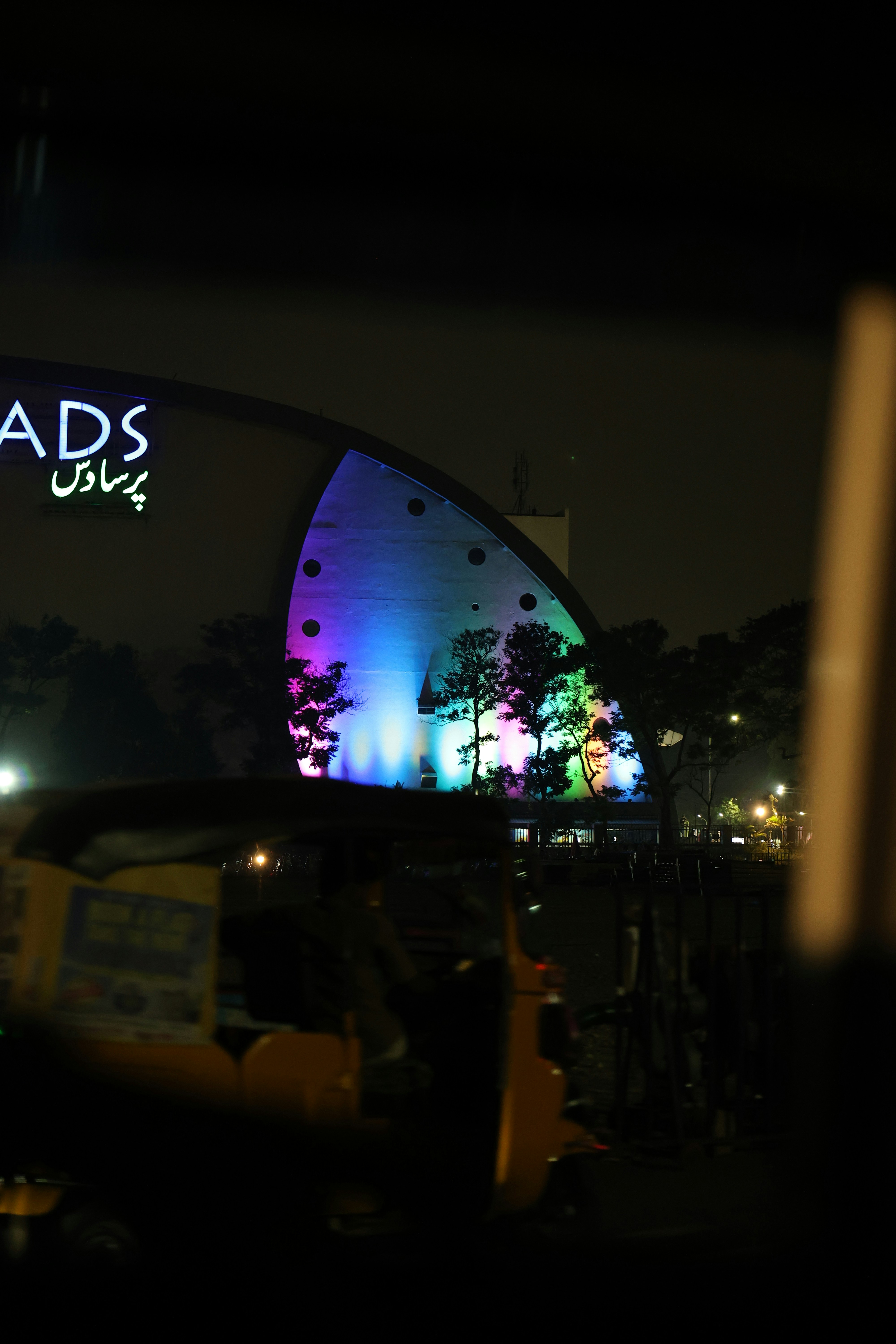 Modern building illuminated with colorful lights at night.