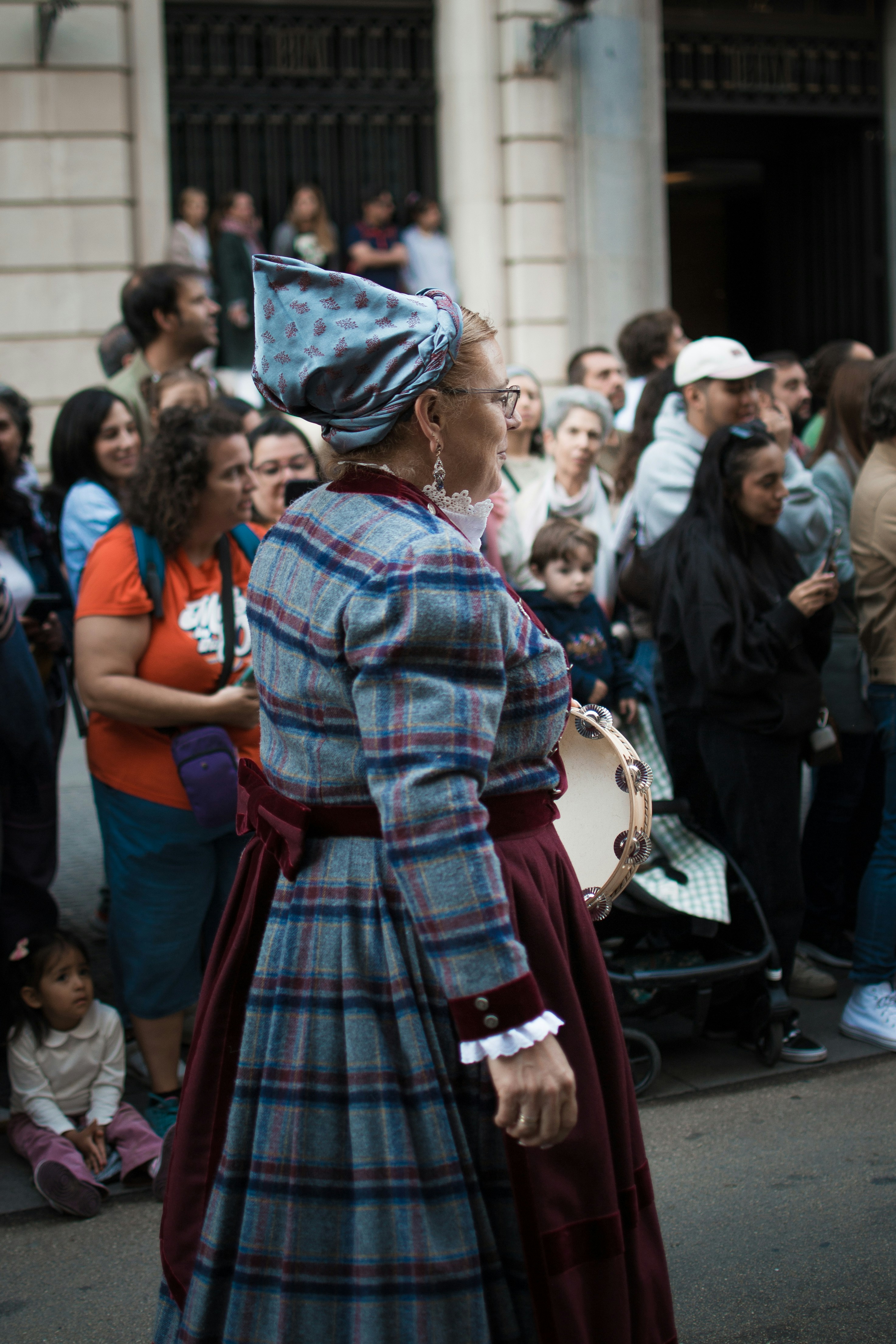 Donna in abito tradizionale con folla in una folla