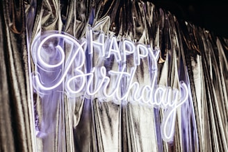Happy birthday neon sign on shiny curtains
