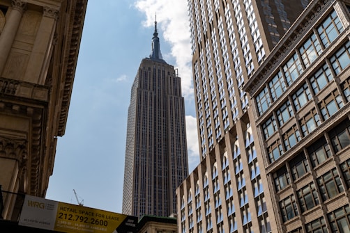 Empire state building against a bright blue sky.