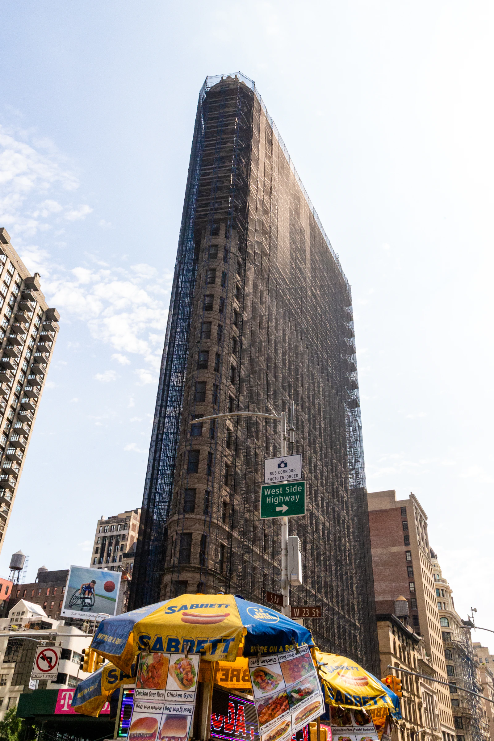 An iconic building wrapped in scaffolding, velocity out ahead of the frame that holds it up.