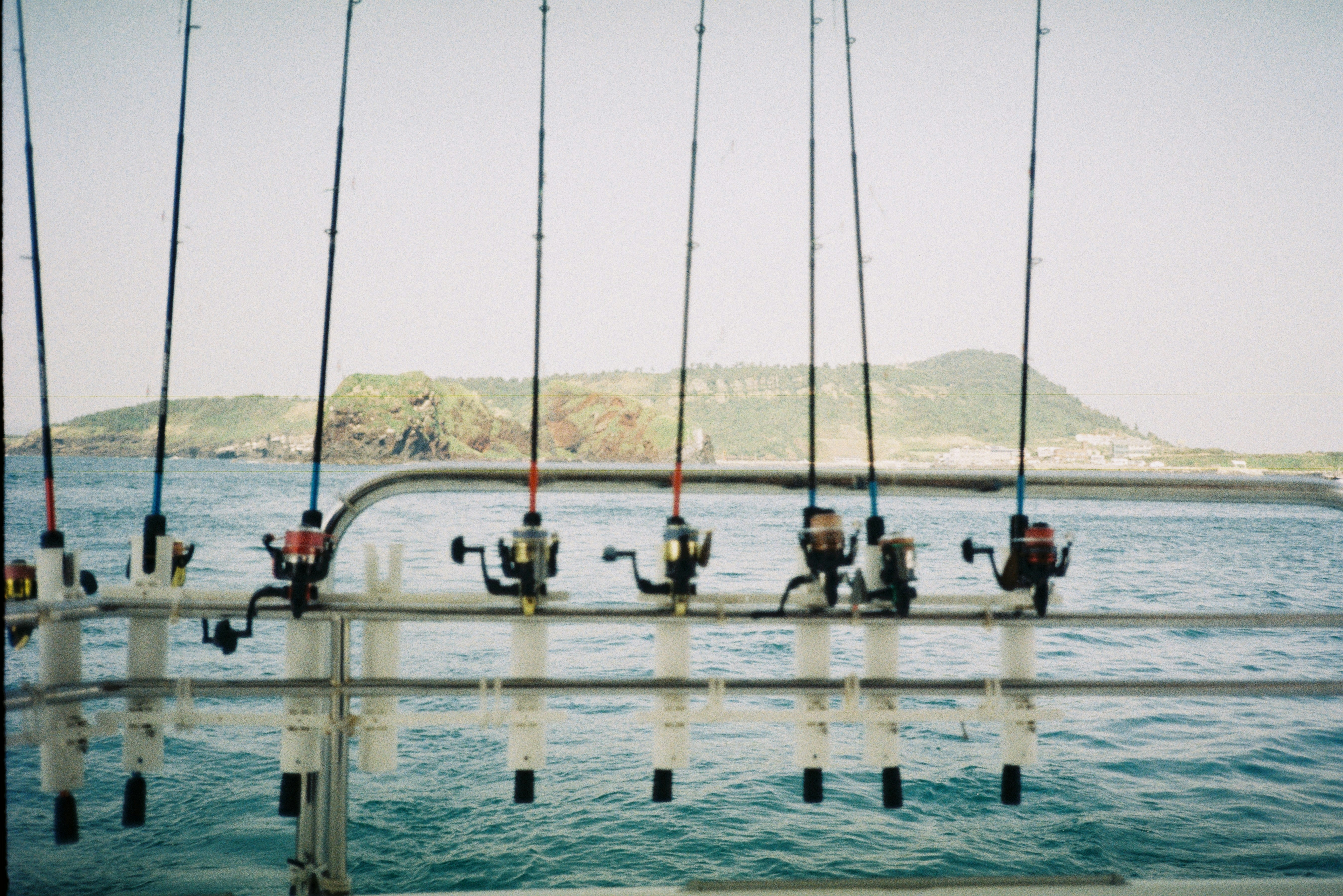 Fishing rods on a boat with island background