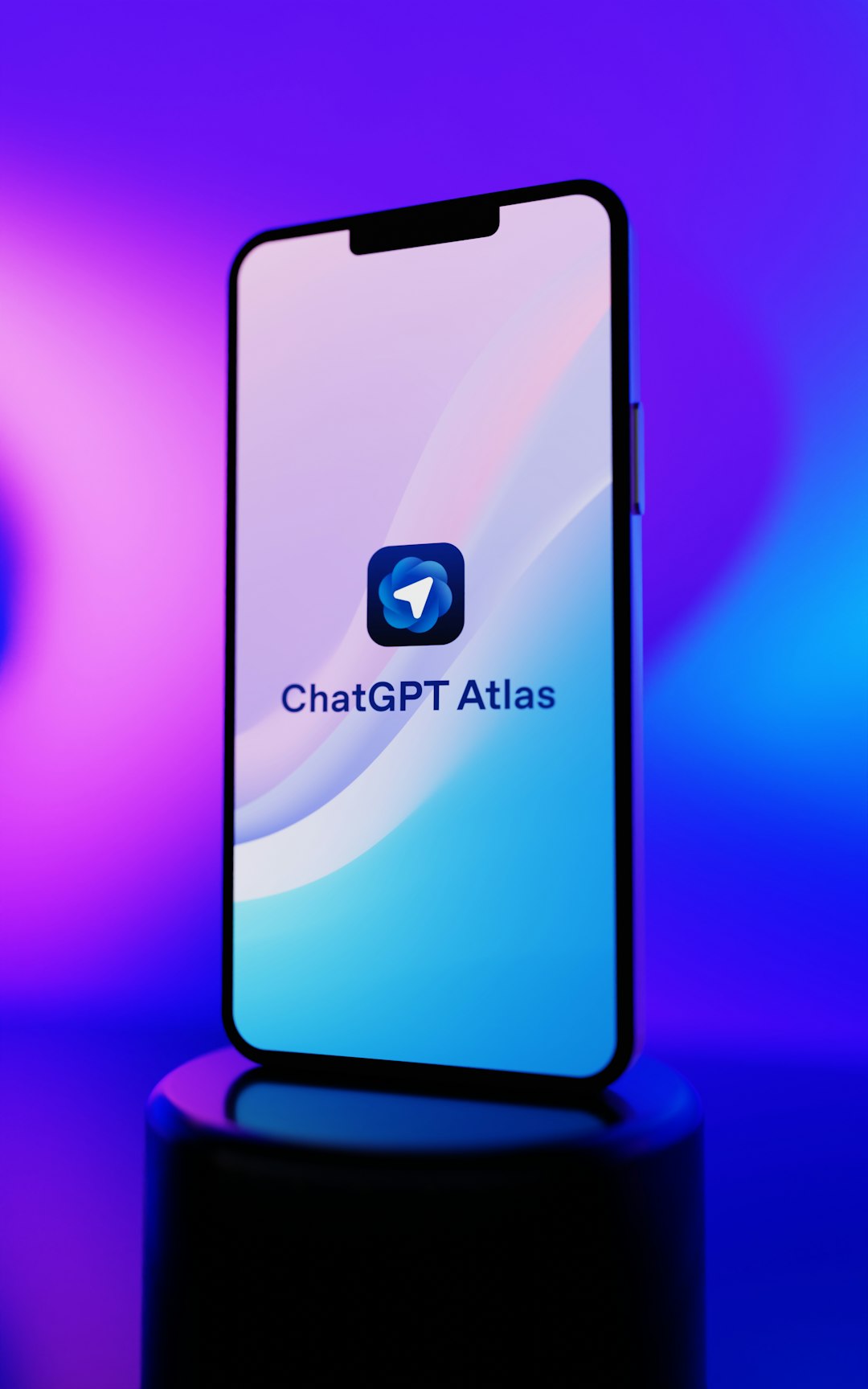 Smartphone displaying chatgpt atlas app on a pedestal.