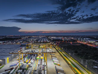 Busy shipping port with cranes and containers at dusk