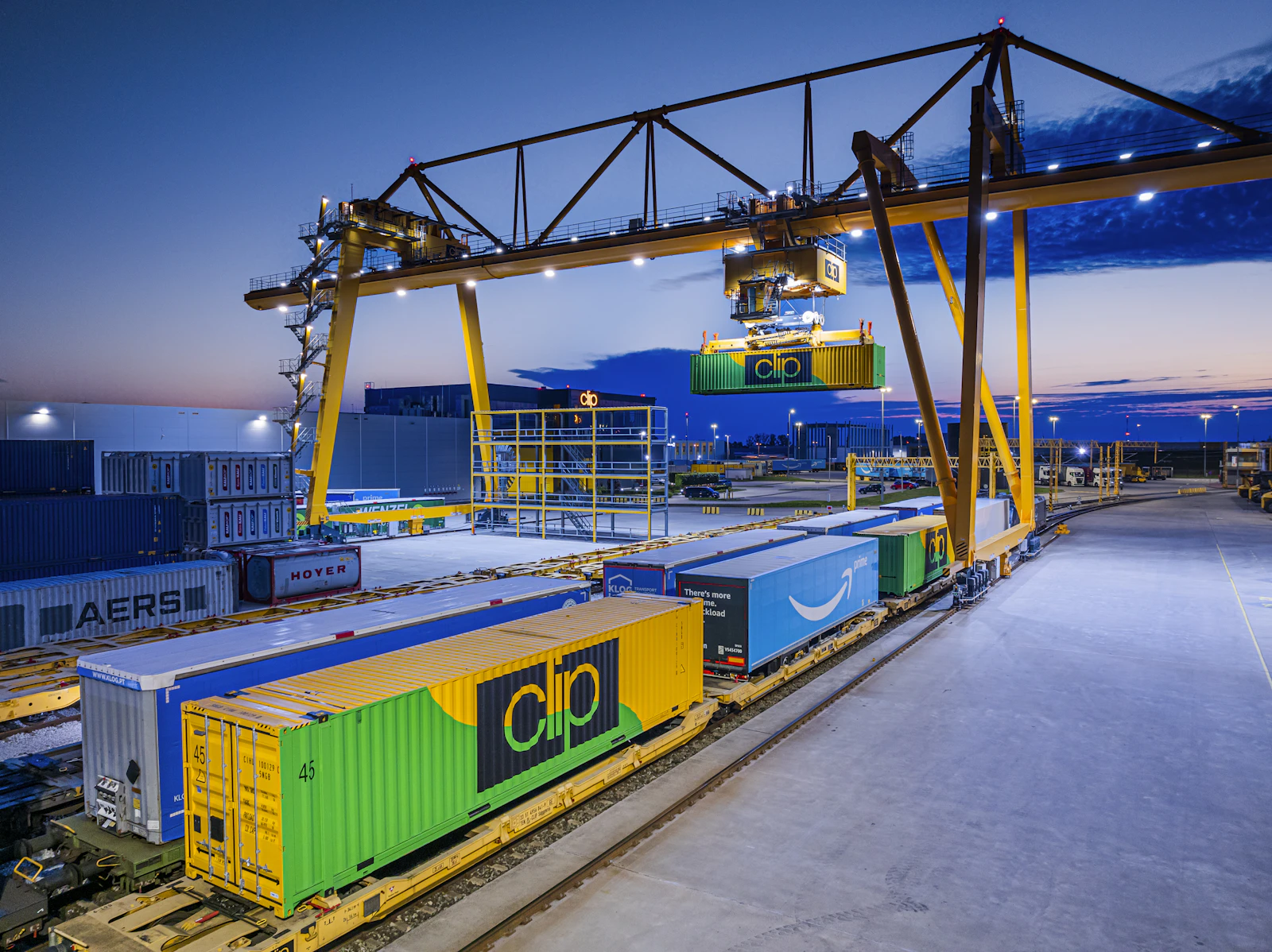 Portal vinç altında blok tren ve konteyner vagonları — alacakaranlık