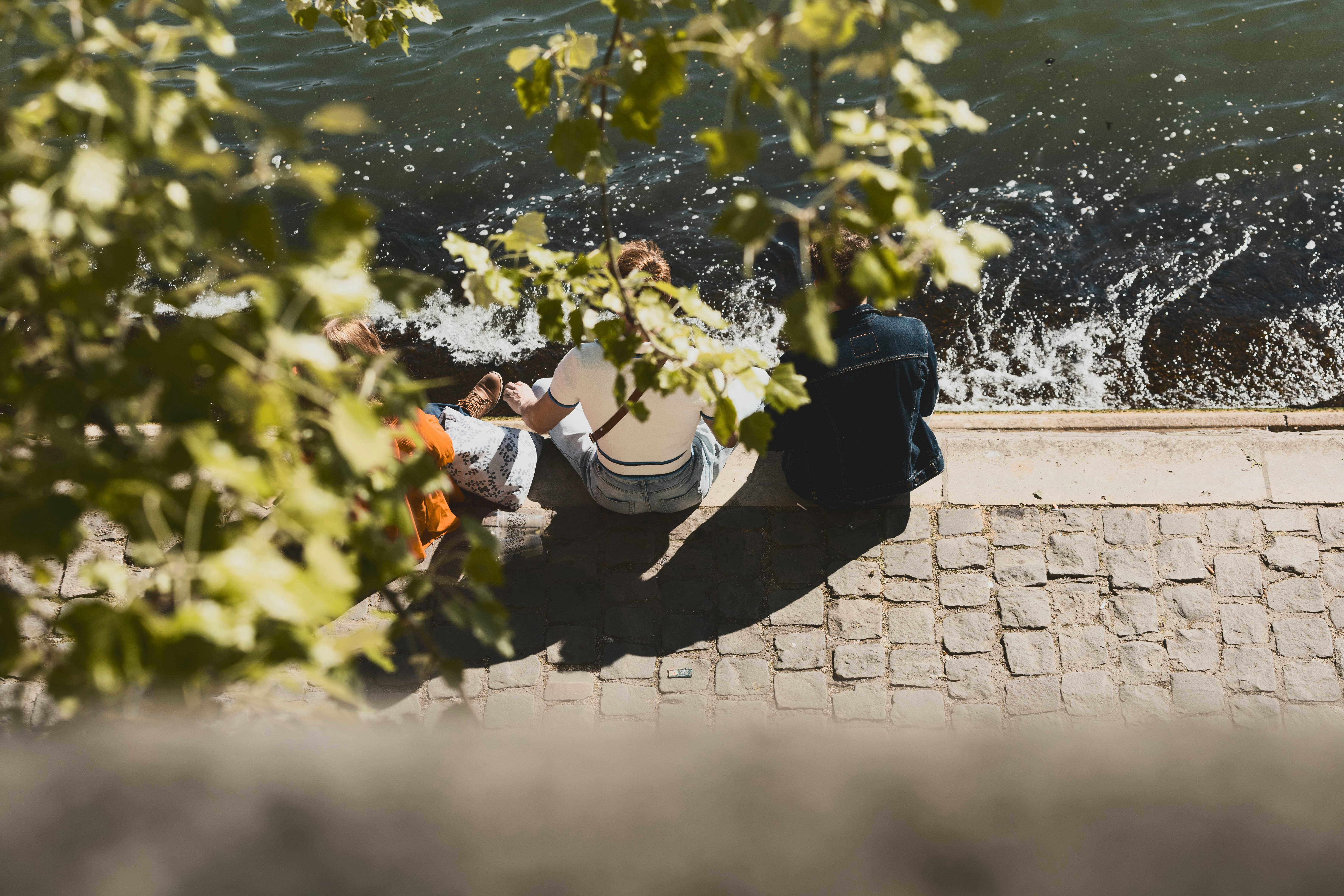 Two people sitting by the water's edge
