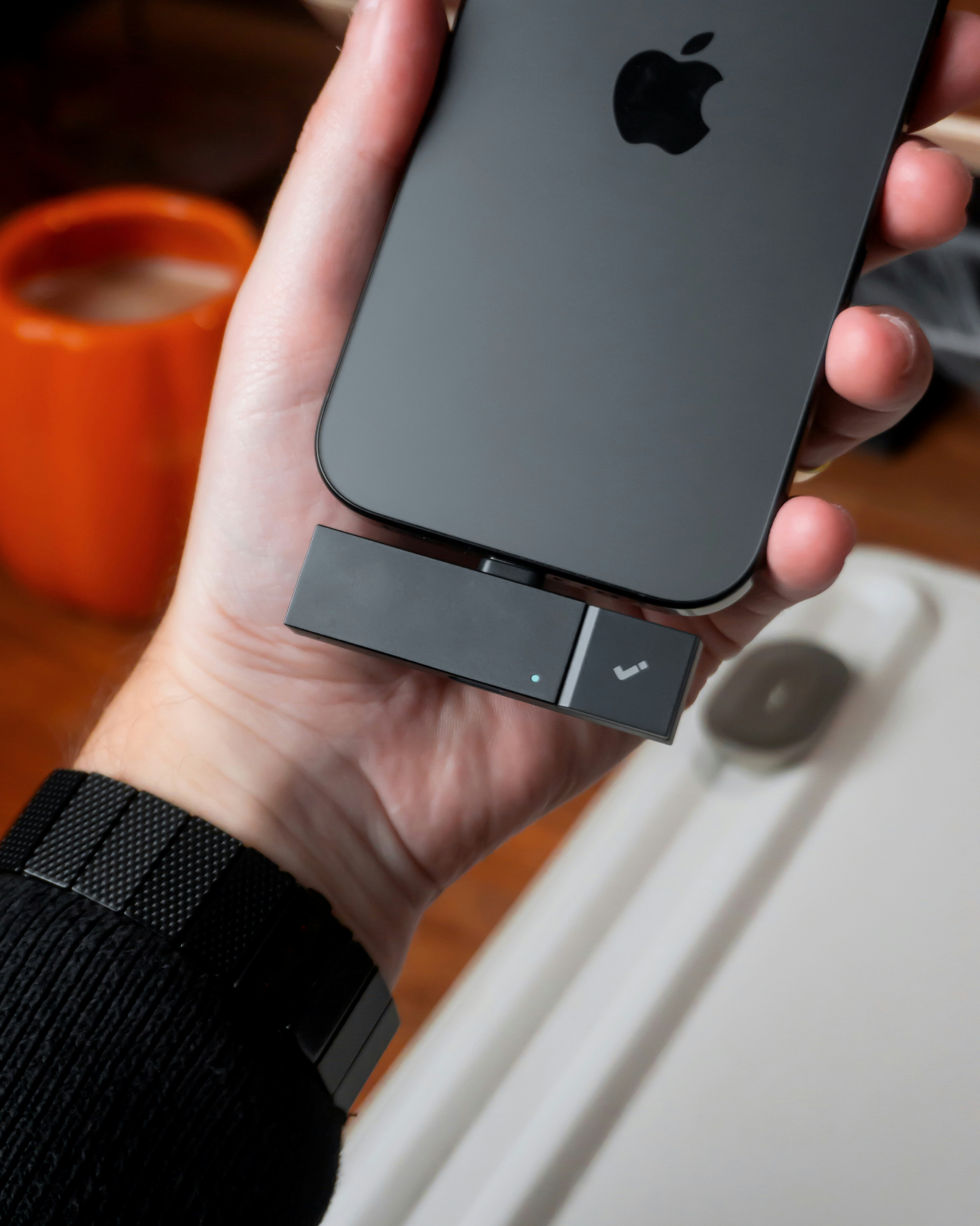 Hand holding phone with attached device