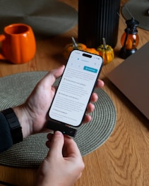 Hands holding a smartphone connected to a charger