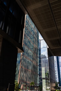 Modern glass buildings reflecting the sky and clouds.