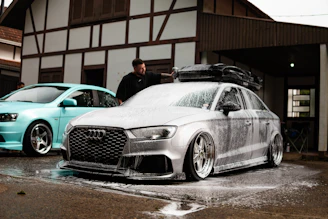 Man washing a silver audi with foam